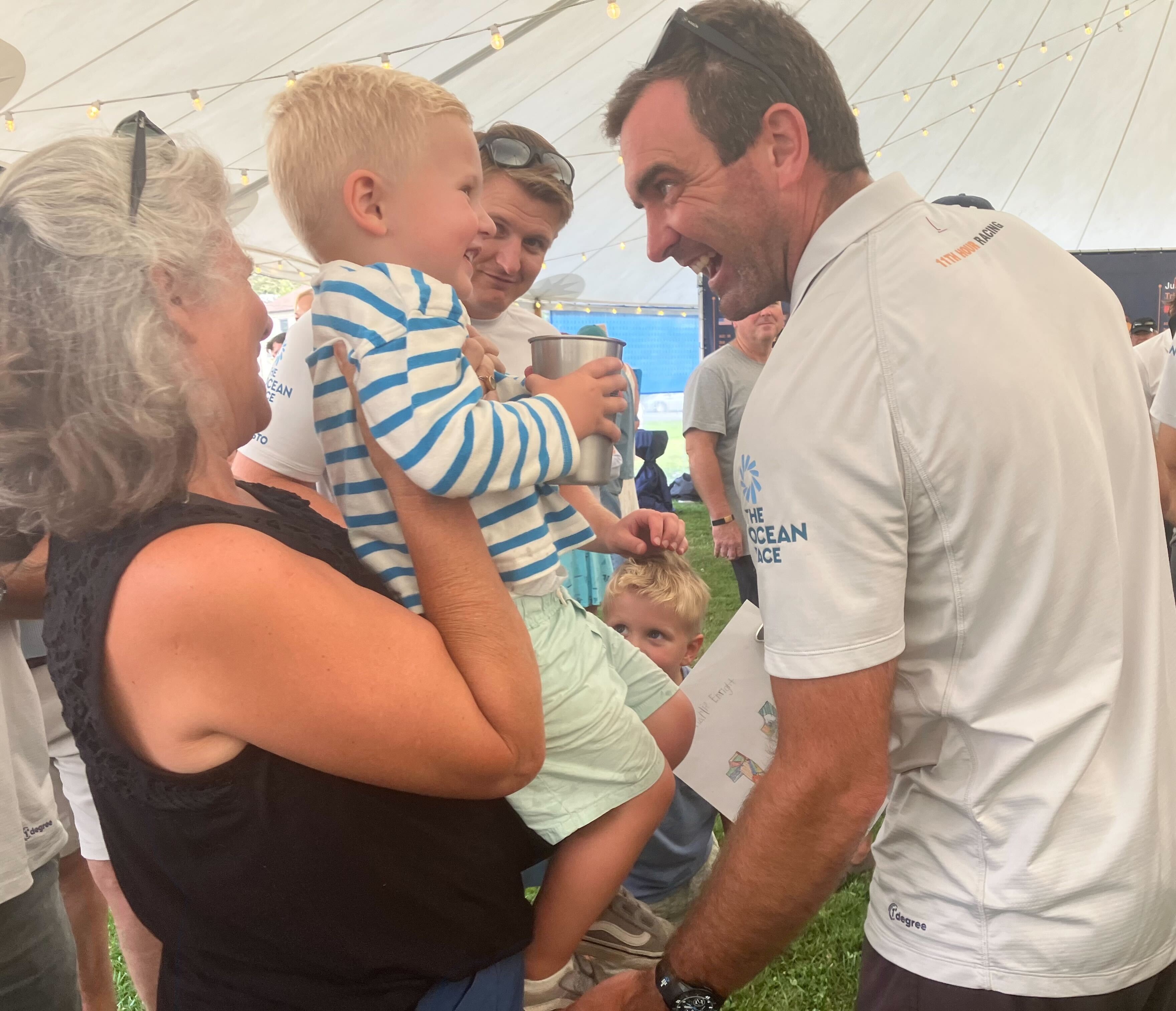Skipper Charlie Enright, of Bristol, greets a young fan at the community celebration event of the 11th Hour Racing team's victory in the round-the-world Ocean Race in Newport on Friday, August 4, 2023. Enright and the 11th 