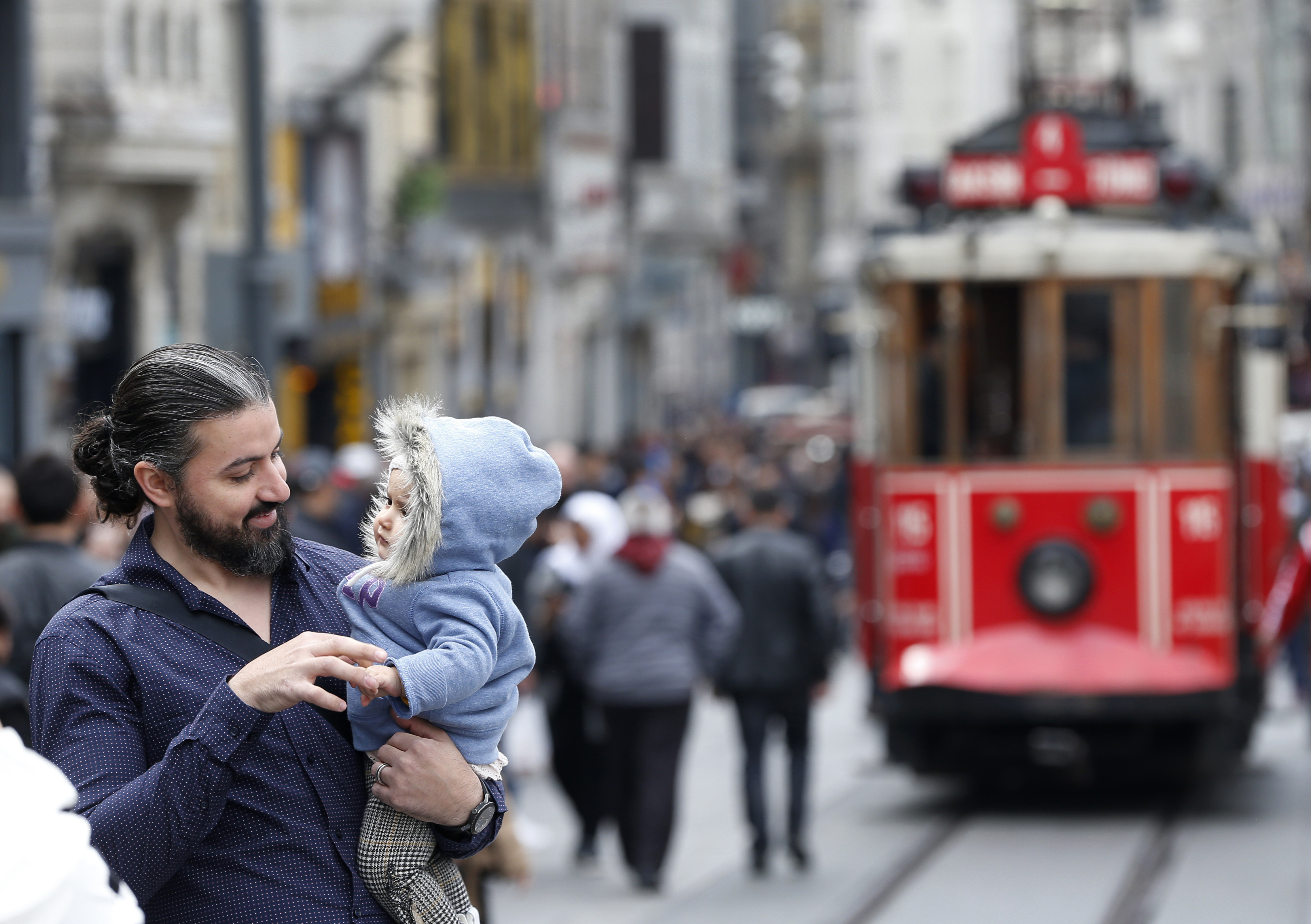 In this Thursday, April 4, 2019 photo, a man holds his baby, in Istiklal street, the main shopping street in Istanbul. The mood among opposition supporters in Turkey's biggest city is one of jubilation but also worry - fear that their win in Istanbul's mayoral race could be overturned in a recount taking place after the ruling party challenged the election results. (AP Photo/Lefteris Pitarakis) In this Thursday, April 4, 2019 photo, a man holds his baby, in Istiklal street, the main shopping street in Istanbul. The mood among opposition supporters in Turkey's biggest city is one of jubilation but also worry - fear that their win in Istanbul's mayoral race could be overturned in a recount taking place after the ruling party challenged the election results. (AP Photo/Lefteris Pitarakis)