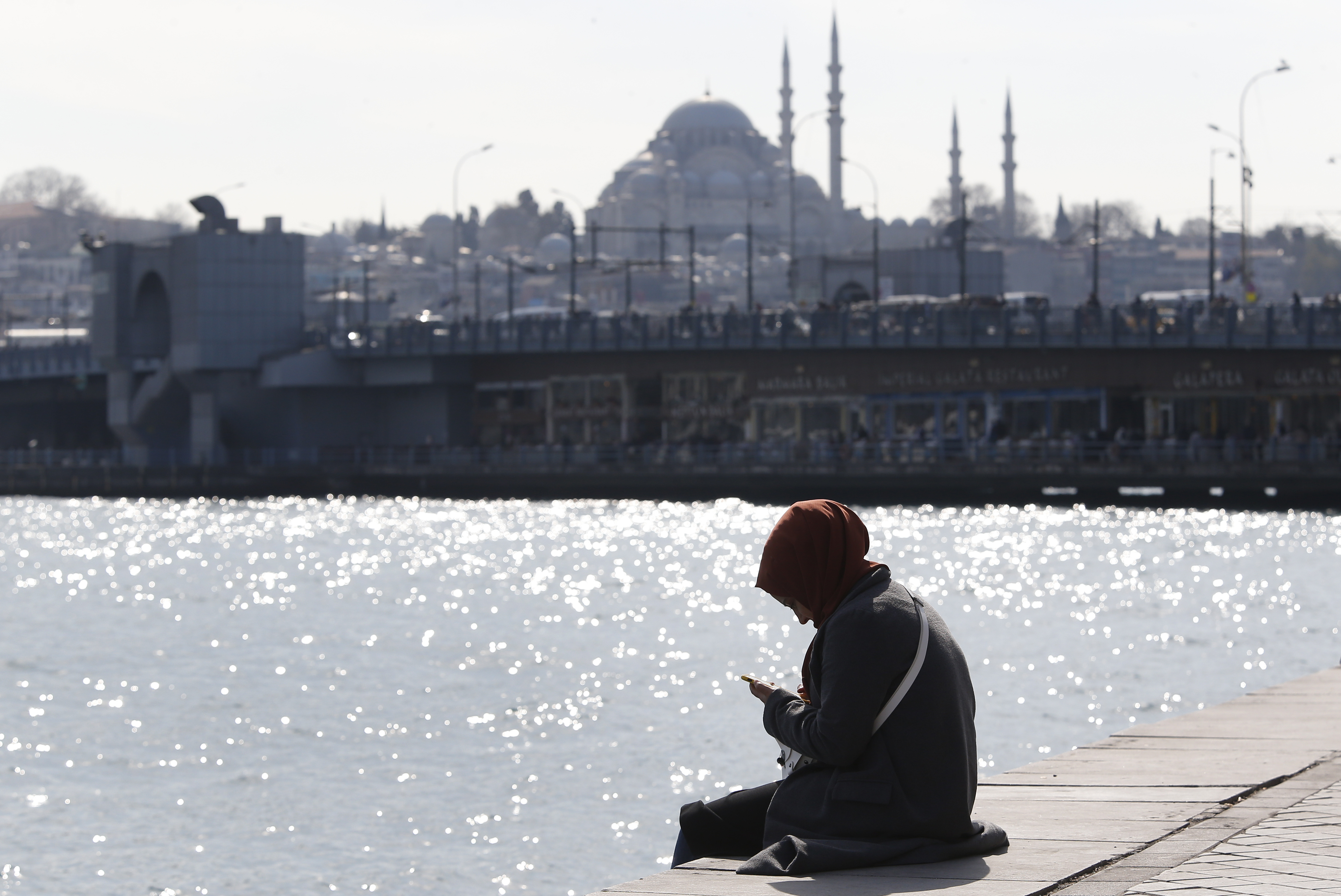 In this Thursday, April 4, 2019 photo, a woman, backdropped by the Suleymaniye mosque, sits by the Golden Horn in Istanbul. The mood among opposition supporters in Turkey's biggest city is one of jubilation but also worry - fear that their win in Istanbul's mayoral race could be overturned in a recount taking place after the ruling party challenged the election results. (AP Photo/Lefteris Pitarakis) In this Thursday, April 4, 2019 photo, a woman, backdropped by the Suleymaniye mosque, sits by the Golden Horn in Istanbul. The mood among opposition supporters in Turkey's biggest city is one of jubilation but also worry - fear that their win in Istanbul's mayoral race could be overturned in a recount taking place after the ruling party challenged the election results. (AP Photo/Lefteris Pitarakis)