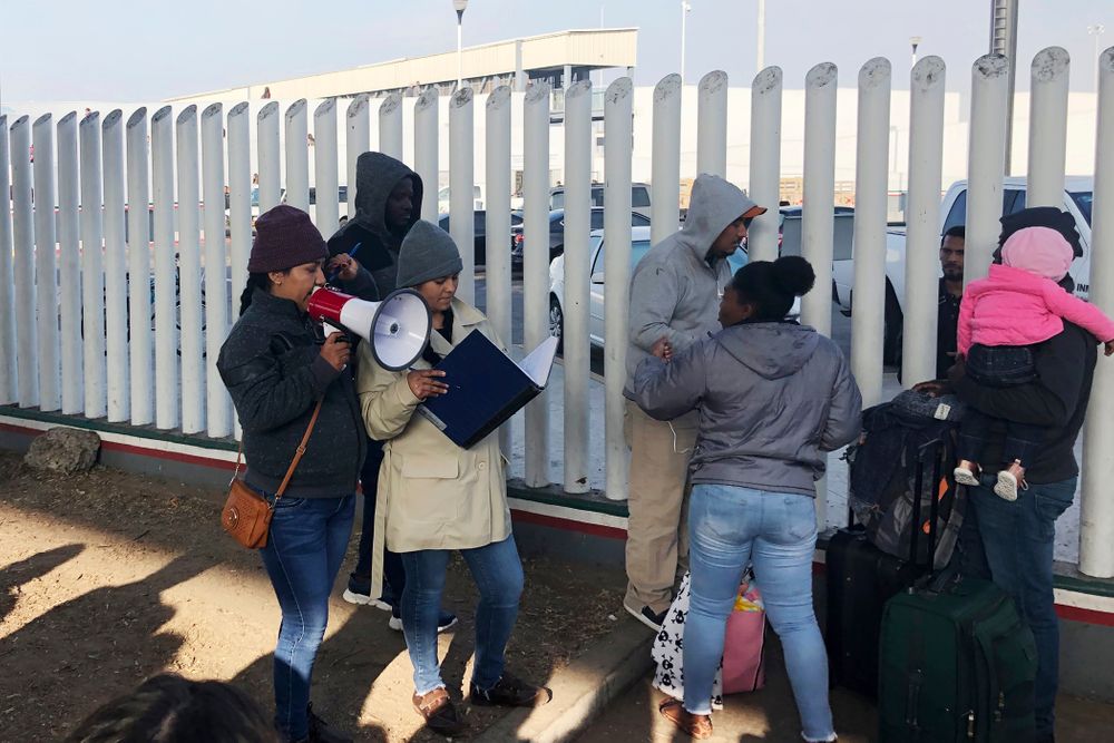 In this Nov. 12, 2019, photo, volunteers call names of people on a waiting list trying to obtain asylum in the United States along the U.S.-Mexico border in Tijuana, Mexico. The U.S. has sent a Honduran migrant back to Guatemala in a move that marked a new phase of President Donald Trump’s immigration crackdown. (AP Photo/Elliot Spagat) In this Nov. 12, 2019, photo, volunteers call names of people on a waiting list trying to obtain asylum in the United States along the U.S.-Mexico border in Tijuana, Mexico. The U.S. has sent a Honduran migrant back to Guatemala in a move that marked a new phase of President Donald Trump’s immigration crackdown. (AP Photo/Elliot Spagat)