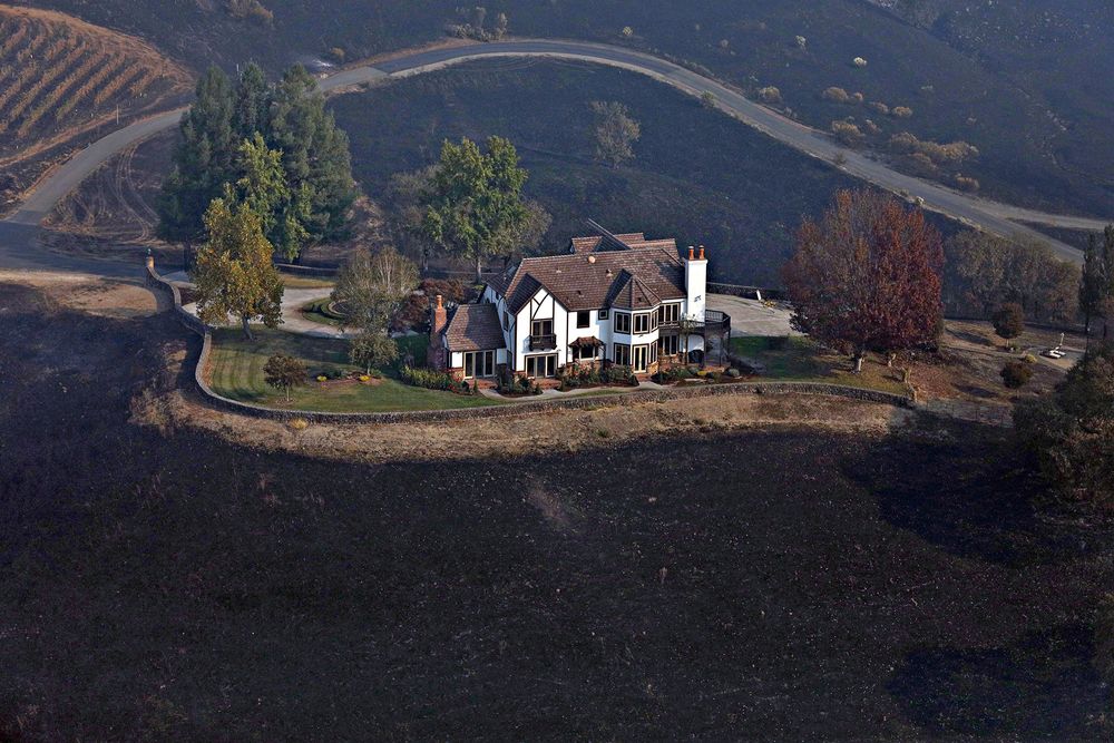 A home between Healdsburg and Windsor, Calif., on Tuesday, Oct. 29, 2019, is surrounded by charred ground but was spared from the Kincade Fire flames. Frustration and anger mounted across Northern California on Tuesday as the state’s biggest utility, Pacific Gas & Electric, began another round of widespread blackouts aimed at preventing its electrical equipment from sparking wildfires in high winds. (Guy Wathen/San Francisco Chronicle via AP) A home between Healdsburg and Windsor, Calif., on Tuesday, Oct. 29, 2019, is surrounded by charred ground but was spared from the Kincade Fire flames. Frustration and anger mounted across Northern California on Tuesday as the state’s biggest utility, Pacific Gas & Electric, began another round of widespread blackouts aimed at preventing its electrical equipment from sparking wildfires in high winds. (Guy Wathen/San Francisco Chronicle via AP)