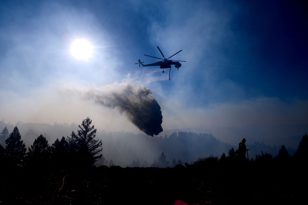 A helicopter drops water while battling the Kincade Fire near Healdsburg, Calif., on Tuesday, Oct. 29, 2019. Millions of people have been without power for days as fire crews race to contain two major wind-whipped blazes that have destroyed dozens of homes at both ends of the state: in Sonoma County wine country and in the hills of Los Angeles. (AP Photo/Noah Berger) A helicopter drops water while battling the Kincade Fire near Healdsburg, Calif., on Tuesday, Oct. 29, 2019. Millions of people have been without power for days as fire crews race to contain two major wind-whipped blazes that have destroyed dozens of homes at both ends of the state: in Sonoma County wine country and in the hills of Los Angeles. (AP Photo/Noah Berger)