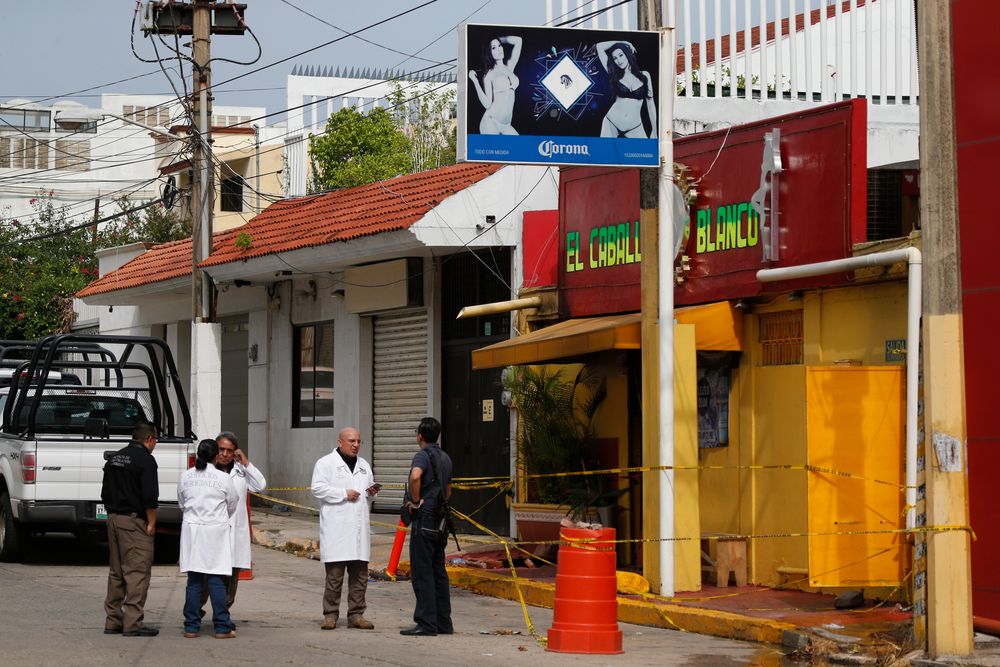 Investigators work outside the White Horse nightclub, the scene of a Tuesday night attack that killed more than two dozen staff and patrons, in Coatzacoalcos, Veracruz state, Mexico, Thursday, Aug. 29, 2019. Anger is mounting among relatives of 28 people who died horrendously when gang members set the nightclub on fire after blocking its exits. The families complained that criminals are out of control and making life impossible in this southern Mexico oil town. (AP Photo/Rebecca Blackwell) Investigators work outside the White Horse nightclub, the scene of a Tuesday night attack that killed more than two dozen staff and patrons, in Coatzacoalcos, Veracruz state, Mexico, Thursday, Aug. 29, 2019. Anger is mounting among relatives of 28 people who died horrendously when gang members set the nightclub on fire after blocking its exits. The families complained that criminals are out of control and making life impossible in this southern Mexico oil town. (AP Photo/Rebecca Blackwell)
