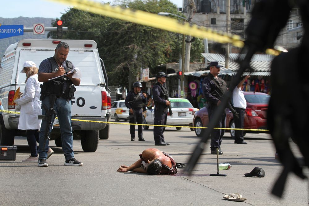 FILE - In this June 2, 2019 file photo, the body of a bloodied man lies in the middle of a street where police and forensic workers secure the crime scene in Acapulco, Mexico. Mexico's drug war appears to be back, and it may be worse this time around than in the bloody years of the government's 2006-2012 offensive against drug cartels. Back then, the worst of the violence was confined to a few cities. Now it is spread throughout the country. (AP Photo/Bernardindo Hernandez, File) FILE - In this June 2, 2019 file photo, the body of a bloodied man lies in the middle of a street where police and forensic workers secure the crime scene in Acapulco, Mexico. Mexico's drug war appears to be back, and it may be worse this time around than in the bloody years of the government's 2006-2012 offensive against drug cartels. Back then, the worst of the violence was confined to a few cities. Now it is spread throughout the country. (AP Photo/Bernardindo Hernandez, File)