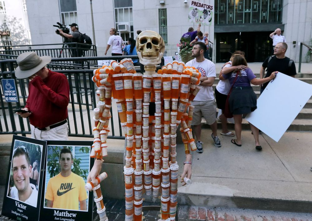 A skeleton of pill bottles stands with protesters outside a courthouse on Friday, Aug. 2, 2019, in Boston, where a judge was to hear arguments in Massachusetts' lawsuit against Purdue Pharma over its role in the national drug epidemic. The skeleton was created by Frank Huntley, of Worcester, Mass., from prescriptions he said he received while addicted to opioids. Organizers of the protest said they wanted to continue to put pressure on the Connecticut pharmaceutical company and the Sackler family that owns it. (AP Photo/Charles Krupa) A skeleton of pill bottles stands with protesters outside a courthouse on Friday, Aug. 2, 2019, in Boston, where a judge was to hear arguments in Massachusetts' lawsuit against Purdue Pharma over its role in the national drug epidemic. The skeleton was created by Frank Huntley, of Worcester, Mass., from prescriptions he said he received while addicted to opioids. Organizers of the protest said they wanted to continue to put pressure on the Connecticut pharmaceutical company and the Sackler family that owns it. (AP Photo/Charles Krupa)
