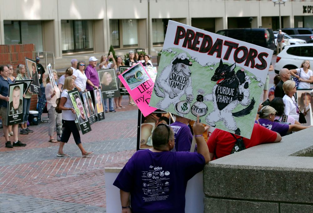 Protesters gather outside a courthouse on Friday, Aug. 2, 2019, in Boston, where a judge was to hear arguments in Massachusetts' lawsuit against Purdue Pharma over its role in the national drug epidemic. Organizers said they wanted to continue to put pressure on the Connecticut pharmaceutical company and the Sackler family that owns it. (AP Photo/Charles Krupa) Protesters gather outside a courthouse on Friday, Aug. 2, 2019, in Boston, where a judge was to hear arguments in Massachusetts' lawsuit against Purdue Pharma over its role in the national drug epidemic. Organizers said they wanted to continue to put pressure on the Connecticut pharmaceutical company and the Sackler family that owns it. (AP Photo/Charles Krupa)
