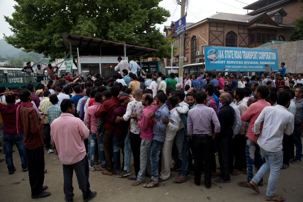 Indian migrant workers wait outside the government transport yard waiting to buy bus tickets to leave the region, during curfew in Srinagar, Indian controlled Kashmir, Wednesday, Aug. 7, 2019. Hit by a complete security lockdown in Kashmir, hundreds of poor migrant workers have begun fleeing the Himalayan region to return to their far-away villages in northern and eastern India. (AP Photo/ Dar Yasin) Indian migrant workers wait outside the government transport yard waiting to buy bus tickets to leave the region, during curfew in Srinagar, Indian controlled Kashmir, Wednesday, Aug. 7, 2019. Hit by a complete security lockdown in Kashmir, hundreds of poor migrant workers have begun fleeing the Himalayan region to return to their far-away villages in northern and eastern India. (AP Photo/ Dar Yasin)