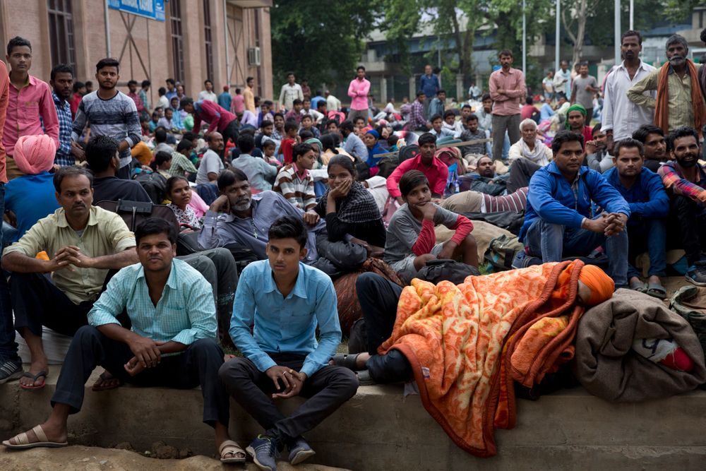 In this Tuesday, Aug. 6, 2019 photo, Indian migrant workers wait outside the government transport yard waiting to buy bus tickets to leave the region, during curfew in Srinagar, Indian controlled Kashmir. Hit by a complete security lockdown in Kashmir, hundreds of poor migrant workers have begun fleeing the Himalayan region to return to their far-away villages in northern and eastern India. (AP Photo/ Dar Yasin) In this Tuesday, Aug. 6, 2019 photo, Indian migrant workers wait outside the government transport yard waiting to buy bus tickets to leave the region, during curfew in Srinagar, Indian controlled Kashmir. Hit by a complete security lockdown in Kashmir, hundreds of poor migrant workers have begun fleeing the Himalayan region to return to their far-away villages in northern and eastern India. (AP Photo/ Dar Yasin)
