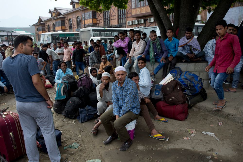 In this Tuesday, Aug. 6, 2019 photo, Indian migrant workers wait outside the government transport yard waiting to buy bus tickets to leave the region, during curfew in Srinagar, Indian controlled Kashmir. Hit by a complete security lockdown in Kashmir, hundreds of poor migrant workers have begun fleeing the Himalayan region to return to their far-away villages in northern and eastern India. (AP Photo/ Dar Yasin) In this Tuesday, Aug. 6, 2019 photo, Indian migrant workers wait outside the government transport yard waiting to buy bus tickets to leave the region, during curfew in Srinagar, Indian controlled Kashmir. Hit by a complete security lockdown in Kashmir, hundreds of poor migrant workers have begun fleeing the Himalayan region to return to their far-away villages in northern and eastern India. (AP Photo/ Dar Yasin)