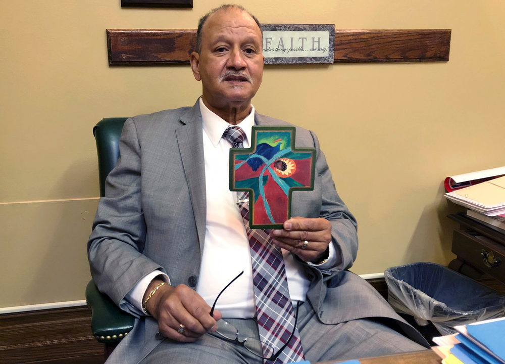 In this Wednesday, May 22, 2019, photo state Democratic Sen. Harold Metts, of Providence, holds one of the crosses decorating his office at the Statehouse in Providence, R.I. Metts, a Baptist deacon, voted against a bill to preserve federal abortion protections in Rhode Island state law, which failed in committee. (AP Photo/Jennifer McDermott) In this Wednesday, May 22, 2019, photo state Democratic Sen. Harold Metts, of Providence, holds one of the crosses decorating his office at the Statehouse in Providence, R.I. Metts, a Baptist deacon, voted against a bill to preserve federal abortion protections in Rhode Island state law, which failed in committee. (AP Photo/Jennifer McDermott)