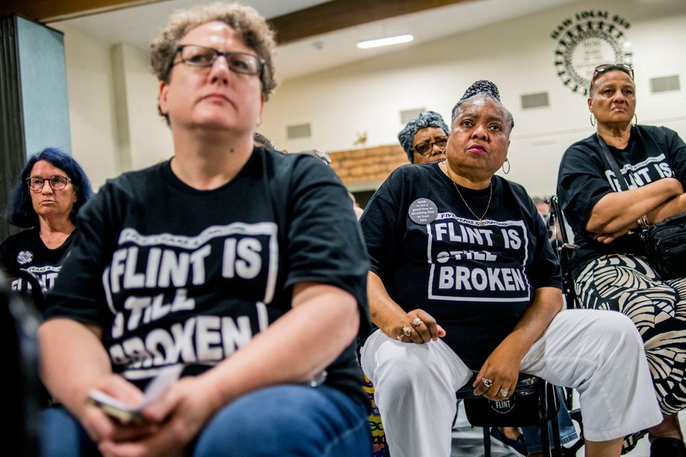 Claudia Perkins-Milton, second right, joins other Flint residents as they show their determination while asking heartfelt, serious questions to Michigan Solicitor General Fadwa Hammoud and Wayne County Prosecutor Kym Worthy during a community meeting with Flint water prosecutors at UAW Local 659 on Friday, June 28, 2019, in Flint, Mich. Prosecutors who dropped charges against eight people in the Flint water scandal explained their decision in a public forum Friday night, telling frustrated and shocked residents they must look at hundreds of mobile devices and millions of documents that a previous investigative team never reviewed. (Jake May/MLive.com/The Flint Journal via AP) Claudia Perkins-Milton, second right, joins other Flint residents as they show their determination while asking heartfelt, serious questions to Michigan Solicitor General Fadwa Hammoud and Wayne County Prosecutor Kym Worthy during a community meeting with Flint water prosecutors at UAW Local 659 on Friday, June 28, 2019, in Flint, Mich. Prosecutors who dropped charges against eight people in the Flint water scandal explained their decision in a public forum Friday night, telling frustrated and shocked residents they must look at hundreds of mobile devices and millions of documents that a previous investigative team never reviewed. (Jake May/MLive.com/The Flint Journal via AP)