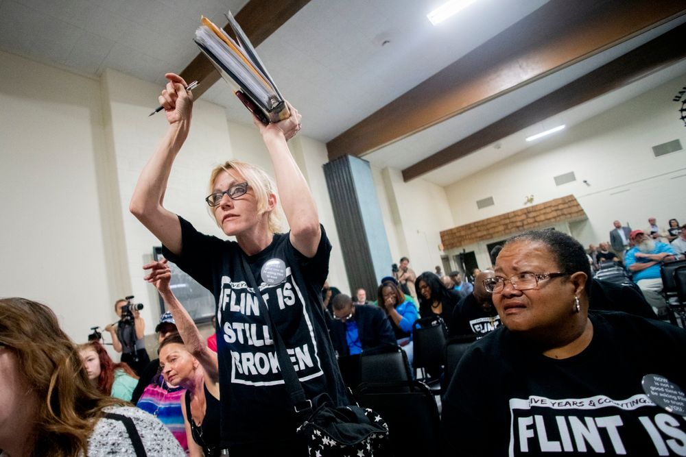 Flint resident Christina Murphy stands up and points at a binder of documents she has kept while listening to answers to resident questions from Michigan Solicitor General Fadwa Hammoud and Wayne County Prosecutor Kym Worthy as about 100 area residents gathered during a community meeting with Flint water prosecutors at UAW Local 659, Friday, June 28, 2019, in Flint, Mich. Michigan Solicitor General Fadwa Hammoud and Wayne County Prosecutor Kym Worthy spoke to residents Friday night, two weeks after dismissing charges against the former state health director and other officials. (Jake May/MLive.com/The Flint Journal via AP) Flint resident Christina Murphy stands up and points at a binder of documents she has kept while listening to answers to resident questions from Michigan Solicitor General Fadwa Hammoud and Wayne County Prosecutor Kym Worthy as about 100 area residents gathered during a community meeting with Flint water prosecutors at UAW Local 659, Friday, June 28, 2019, in Flint, Mich. Michigan Solicitor General Fadwa Hammoud and Wayne County Prosecutor Kym Worthy spoke to residents Friday night, two weeks after dismissing charges against the former state health director and other officials. (Jake May/MLive.com/The Flint Journal via AP)