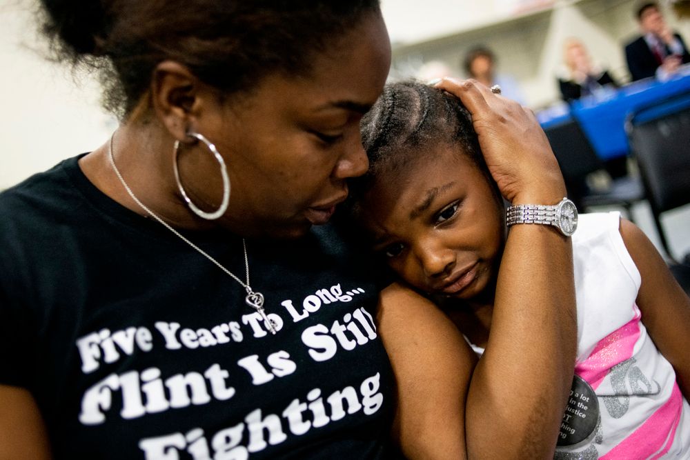 Flint resident Ariana Hawk consoles her daughter Aliana, 4, nearing the end of a two-hour community meeting with Flint water prosecutors at UAW Local 659, Friday, June 28, 2019, in Flint, Mich. Hawk is the mother of Sincere Smith, who graced the cover of Time magazine at the height of the Flint water crisis in 2016. Michigan Solicitor General Fadwa Hammoud and Wayne County Prosecutor Kym Worthy spoke to about 100 residents Friday night at a union hall in the city, two weeks after dismissing charges against the former state health director and other officials. (Jake May/MLive.com/The Flint Journal via AP) Flint resident Ariana Hawk consoles her daughter Aliana, 4, nearing the end of a two-hour community meeting with Flint water prosecutors at UAW Local 659, Friday, June 28, 2019, in Flint, Mich. Hawk is the mother of Sincere Smith, who graced the cover of Time magazine at the height of the Flint water crisis in 2016. Michigan Solicitor General Fadwa Hammoud and Wayne County Prosecutor Kym Worthy spoke to about 100 residents Friday night at a union hall in the city, two weeks after dismissing charges against the former state health director and other officials. (Jake May/MLive.com/The Flint Journal via AP)