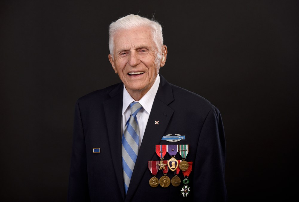 In this May 17, 2019, photo, Steve Melnikoff, who came ashore at Normandy, France on D-Day-plus-1, June 7, 1944, with the 175th Regiment of the 29th Infantry Division, stands in his home in Cockeysville, Md. His unit was part of the bloody campaign to capture the French town of Saint-Lo through fields marked by thick hedgerows that provided perfect cover for German troops. (AP Photo/Steve Ruark) In this May 17, 2019, photo, Steve Melnikoff, who came ashore at Normandy, France on D-Day-plus-1, June 7, 1944, with the 175th Regiment of the 29th Infantry Division, stands in his home in Cockeysville, Md. His unit was part of the bloody campaign to capture the French town of Saint-Lo through fields marked by thick hedgerows that provided perfect cover for German troops. (AP Photo/Steve Ruark)