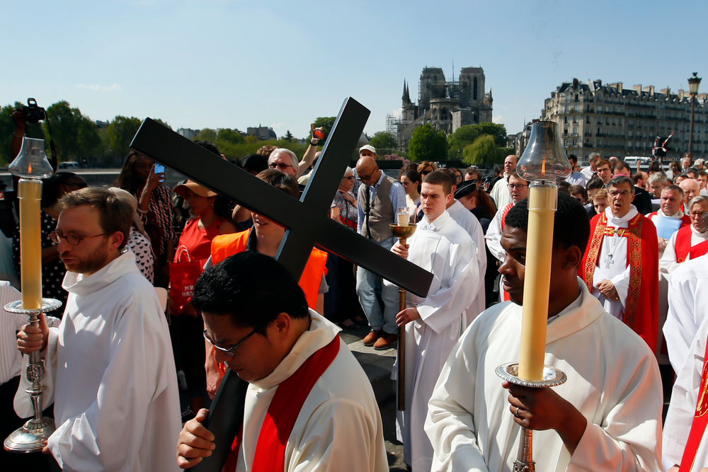 With Notre Dame cathedral in background, religious officials carry the cross during the Good Friday procession, Friday, April 19, 2019 in Paris. Top French art conservation officials say the works inside Notre Dame suffered no major damage in the fire that devastated the cathedral, and the pieces have been removed from the building for their protection.(AP Photo/Francois Mori) With Notre Dame cathedral in background, religious officials carry the cross during the Good Friday procession, Friday, April 19, 2019 in Paris. Top French art conservation officials say the works inside Notre Dame suffered no major damage in the fire that devastated the cathedral, and the pieces have been removed from the building for their protection.(AP Photo/Francois Mori)