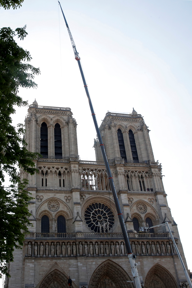 A crane works at Notre-Dame cathedral in Paris, Friday, April 19, 2019. Rebuilding Notre Dame, the 800-year-old Paris cathedral devastated by fire this week, will cost billions of dollars as architects, historians and artisans work to preserve the medieval landmark. (Philippe Wojazer/Pool via AP) A crane works at Notre-Dame cathedral in Paris, Friday, April 19, 2019. Rebuilding Notre Dame, the 800-year-old Paris cathedral devastated by fire this week, will cost billions of dollars as architects, historians and artisans work to preserve the medieval landmark. (Philippe Wojazer/Pool via AP)