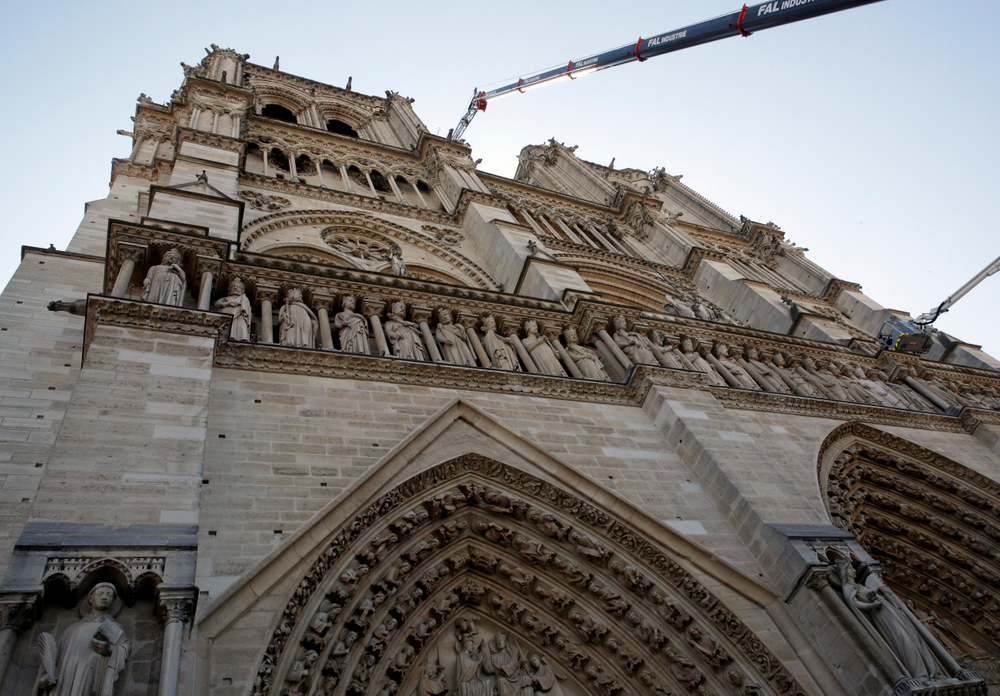 A crane works at Notre-Dame cathedral in Paris, Friday, April 19, 2019. Rebuilding Notre Dame, the 800-year-old Paris cathedral devastated by fire this week, will cost billions of dollars as architects, historians and artisans work to preserve the medieval landmark. (Philippe Wojazer/Pool via AP) A crane works at Notre-Dame cathedral in Paris, Friday, April 19, 2019. Rebuilding Notre Dame, the 800-year-old Paris cathedral devastated by fire this week, will cost billions of dollars as architects, historians and artisans work to preserve the medieval landmark. (Philippe Wojazer/Pool via AP)