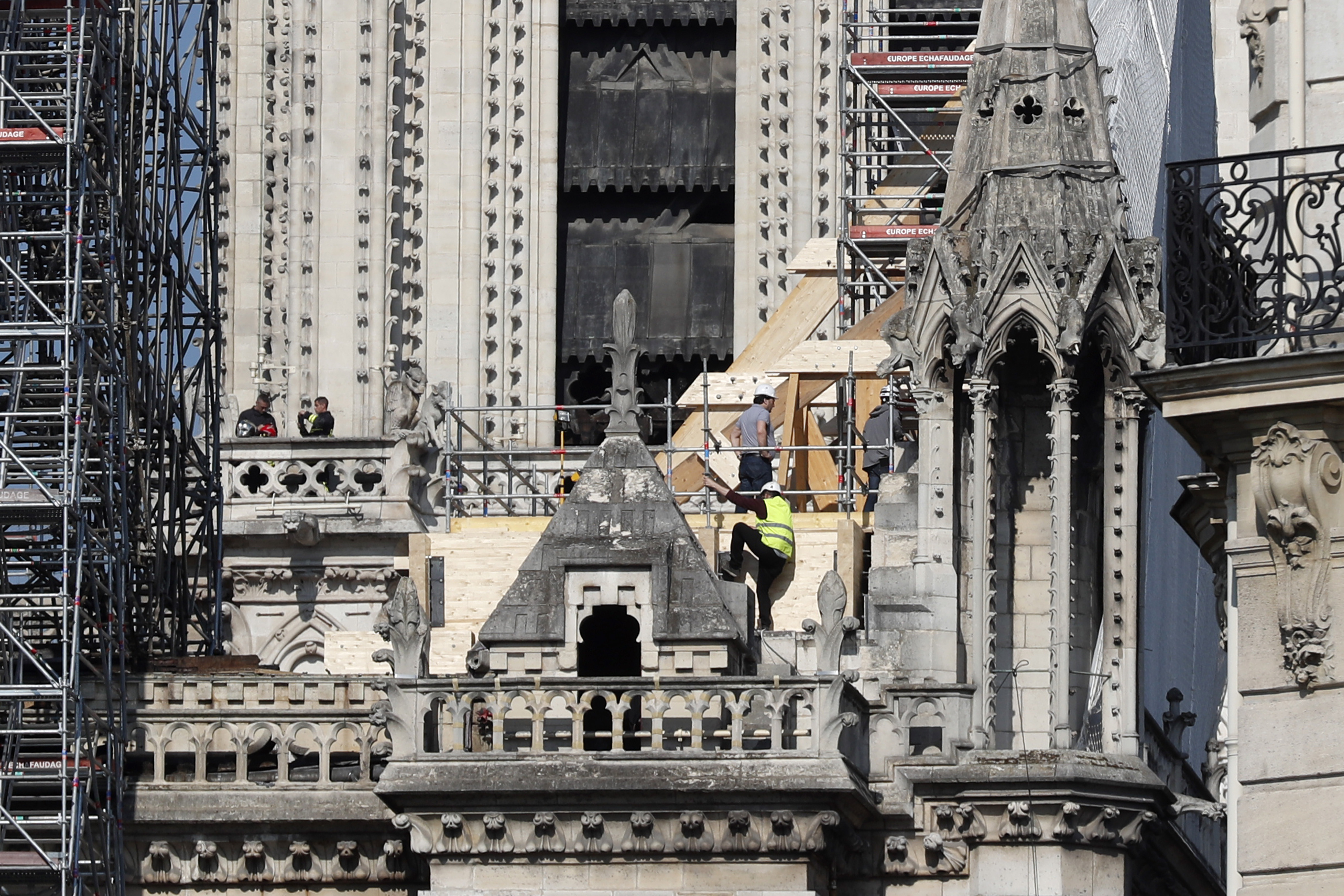 Workers stand by wooden planks supporting Notre Dame cathedral Friday, April 19, 2019 in Paris. Rebuilding Notre Dame, the 800-year-old Paris cathedral devastated by fire this week, will cost billions of dollars as architects, historians and artisans work to preserve the medieval landmark. (AP Photo/Thibault Camus) Workers stand by wooden planks supporting Notre Dame cathedral Friday, April 19, 2019 in Paris. Rebuilding Notre Dame, the 800-year-old Paris cathedral devastated by fire this week, will cost billions of dollars as architects, historians and artisans work to preserve the medieval landmark. (AP Photo/Thibault Camus)