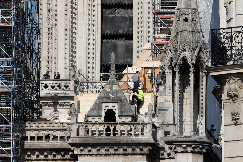 Workers stand by wooden planks supporting Notre Dame cathedral Friday, April 19, 2019 in Paris. Rebuilding Notre Dame, the 800-year-old Paris cathedral devastated by fire this week, will cost billions of dollars as architects, historians and artisans work to preserve the medieval landmark. (AP Photo/Thibault Camus) Workers stand by wooden planks supporting Notre Dame cathedral Friday, April 19, 2019 in Paris. Rebuilding Notre Dame, the 800-year-old Paris cathedral devastated by fire this week, will cost billions of dollars as architects, historians and artisans work to preserve the medieval landmark. (AP Photo/Thibault Camus)