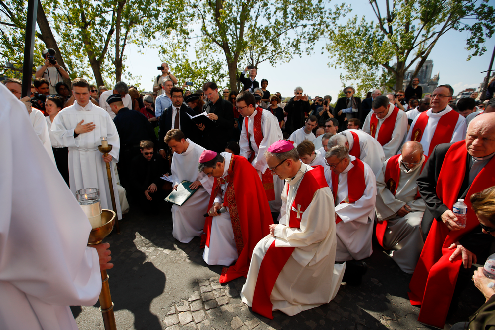 With Notre Dame cathedral, background right, religious officials pray during the Good Friday procession, Friday, April 19, 2019 in Paris. Top French art conservation officials say the works inside Notre Dame suffered no major damage in the fire that devastated the cathedral, and the pieces have been removed from the building for their protection.(AP Photo/Francois Mori) With Notre Dame cathedral, background right, religious officials pray during the Good Friday procession, Friday, April 19, 2019 in Paris. Top French art conservation officials say the works inside Notre Dame suffered no major damage in the fire that devastated the cathedral, and the pieces have been removed from the building for their protection.(AP Photo/Francois Mori)