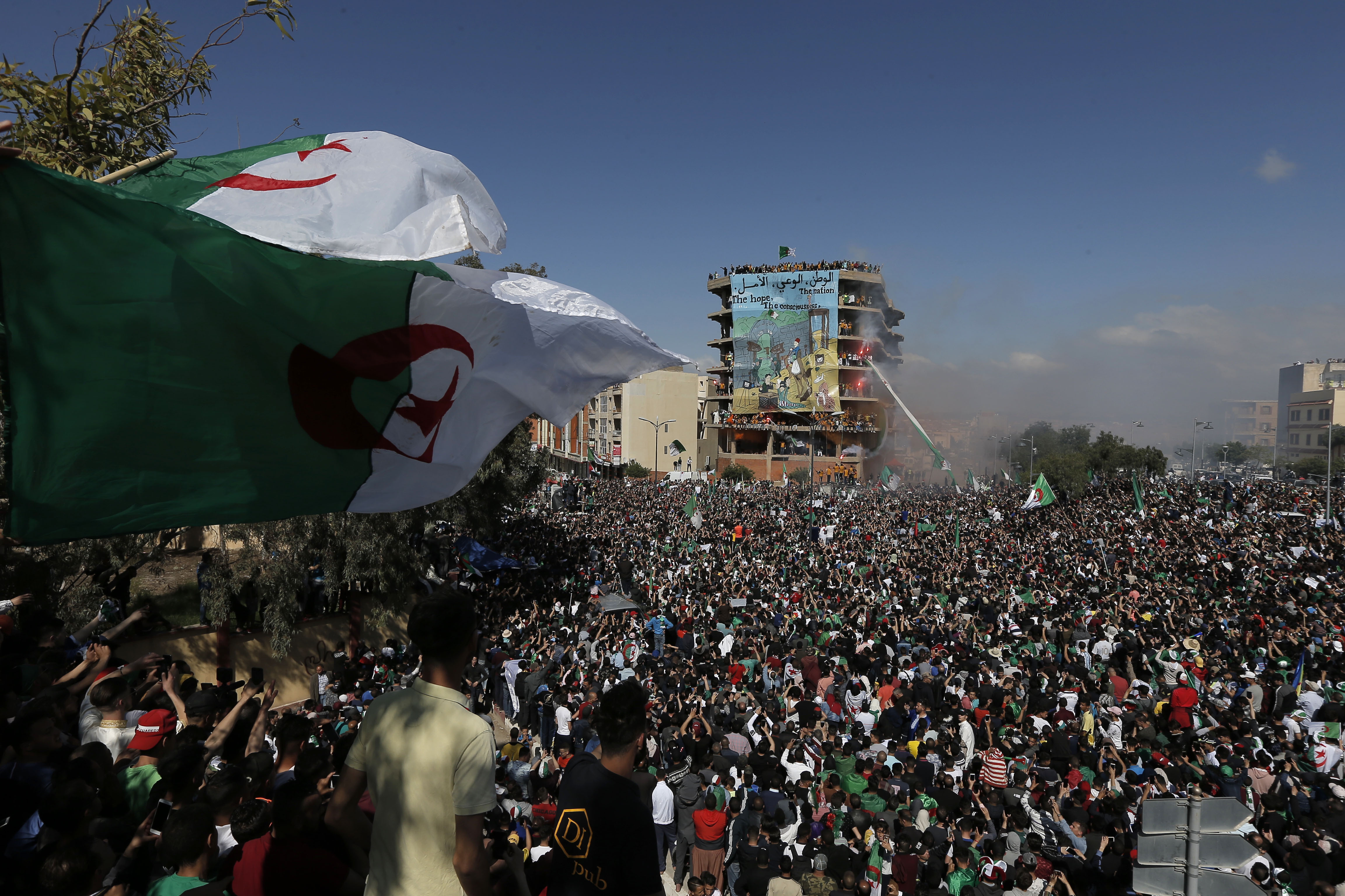 Demonstrators carry a giant Algerian flag during a protest in Bordj Bou Arreridj, east of Algiers, Friday, April 26, 2019. Algerians are massing for a 10th week of protests against their country's ruling class, calling for the ex-president's brother to be put on trial. (AP Photo/Toufik Doudou) Demonstrators carry a giant Algerian flag during a protest in Bordj Bou Arreridj, east of Algiers, Friday, April 26, 2019. Algerians are massing for a 10th week of protests against their country's ruling class, calling for the ex-president's brother to be put on trial. (AP Photo/Toufik Doudou)