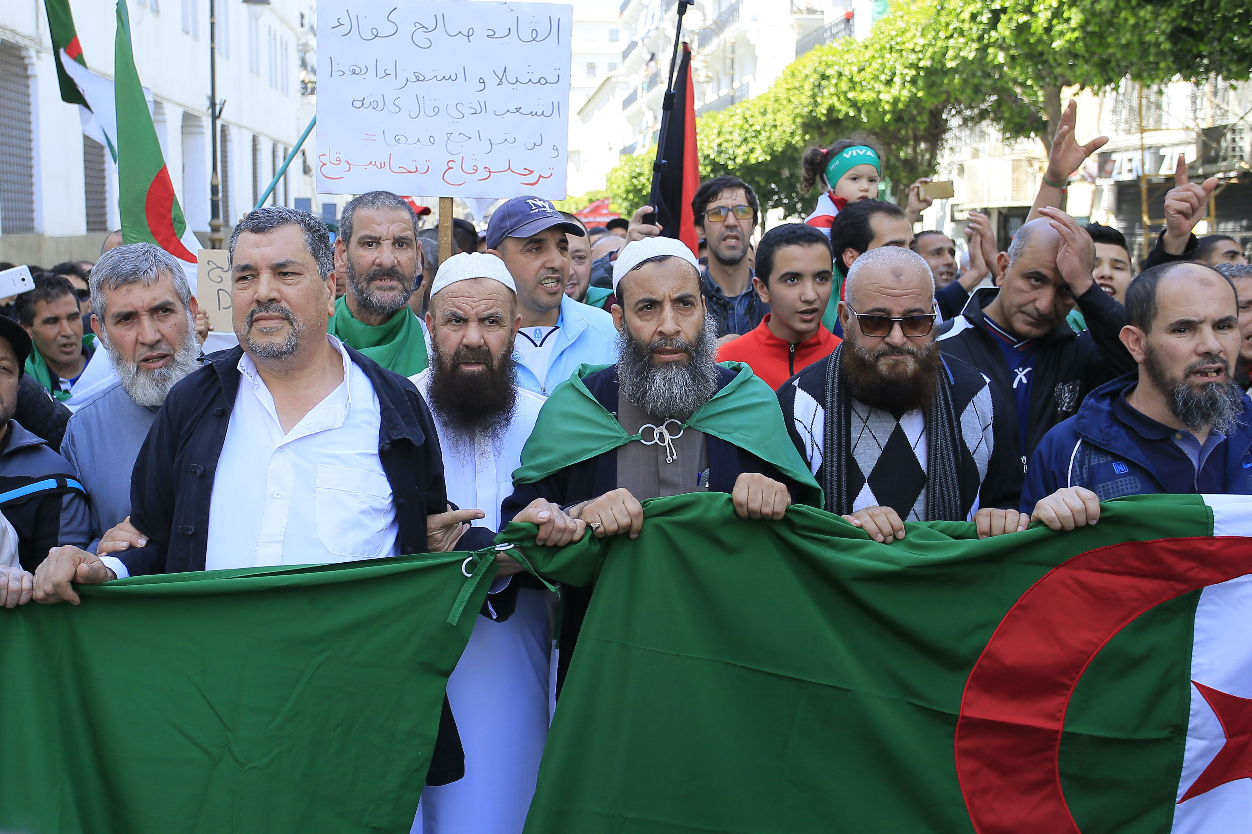 Demonstrators march with the Algerian flag during a protest in Algiers, Friday, April 26, 2019. Algerians are massing for a 10th week of protests against their country's ruling class, calling for the ex-president's brother to be put on trial. (AP Photo/Anis Belghoul) Demonstrators march with the Algerian flag during a protest in Algiers, Friday, April 26, 2019. Algerians are massing for a 10th week of protests against their country's ruling class, calling for the ex-president's brother to be put on trial. (AP Photo/Anis Belghoul)