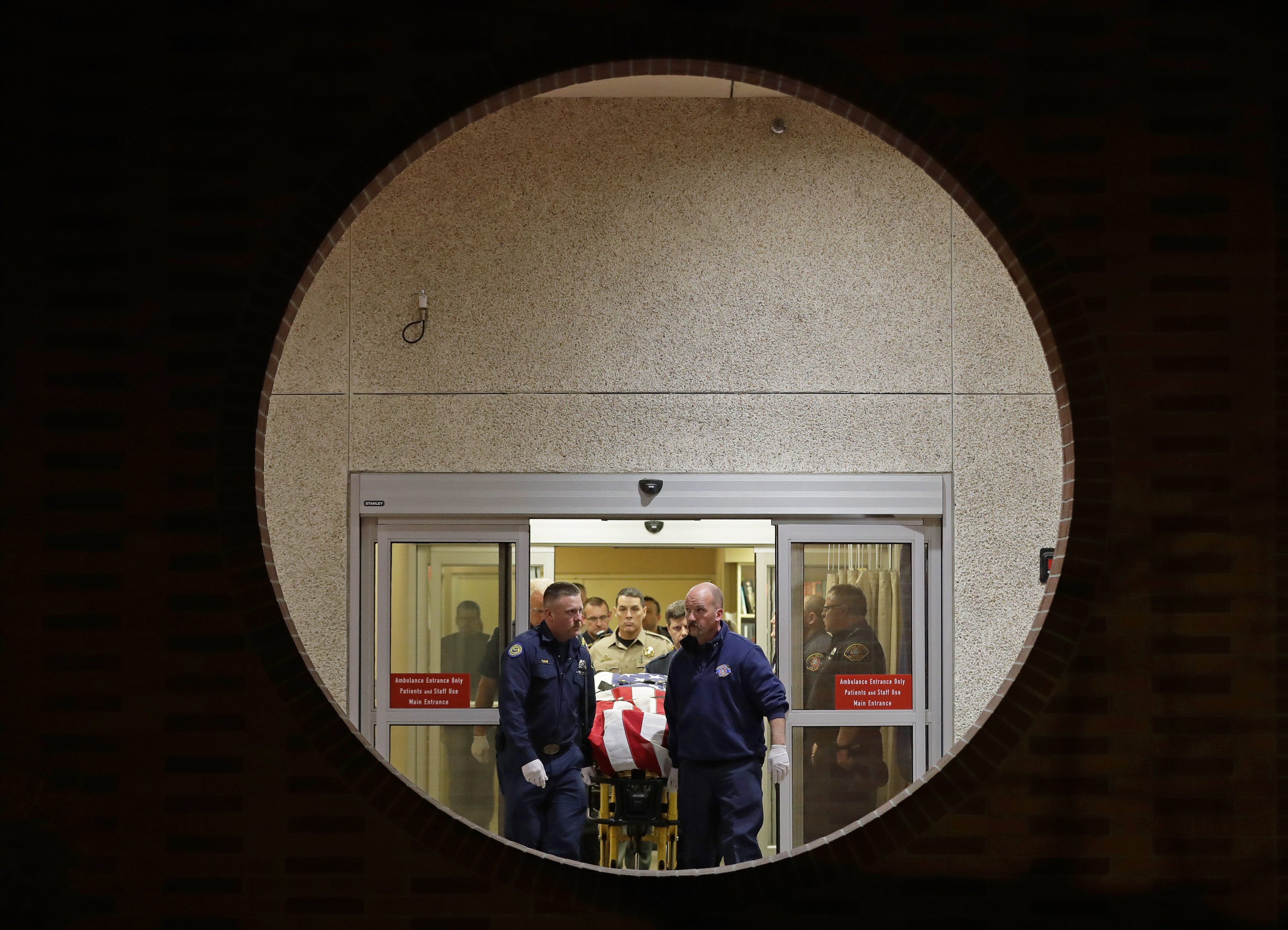 The body of a Kittitas County Sheriff's deputy is draped with a U.S. flag as it is carried out of Kittitas Valley Healthcare Hospital in the early morning hours of Wednesday, March 20, 2019, in Ellensburg, Wash., as seen through a large circular entry window. A sheriff's deputy was killed and a police officer was injured after an exchange of gunfire during an attempted traffic stop. (AP Photo/Ted S. Warren) The body of a Kittitas County Sheriff's deputy is draped with a U.S. flag as it is carried out of Kittitas Valley Healthcare Hospital in the early morning hours of Wednesday, March 20, 2019, in Ellensburg, Wash., as seen through a large circular entry window. A sheriff's deputy was killed and a police officer was injured after an exchange of gunfire during an attempted traffic stop. (AP Photo/Ted S. Warren)