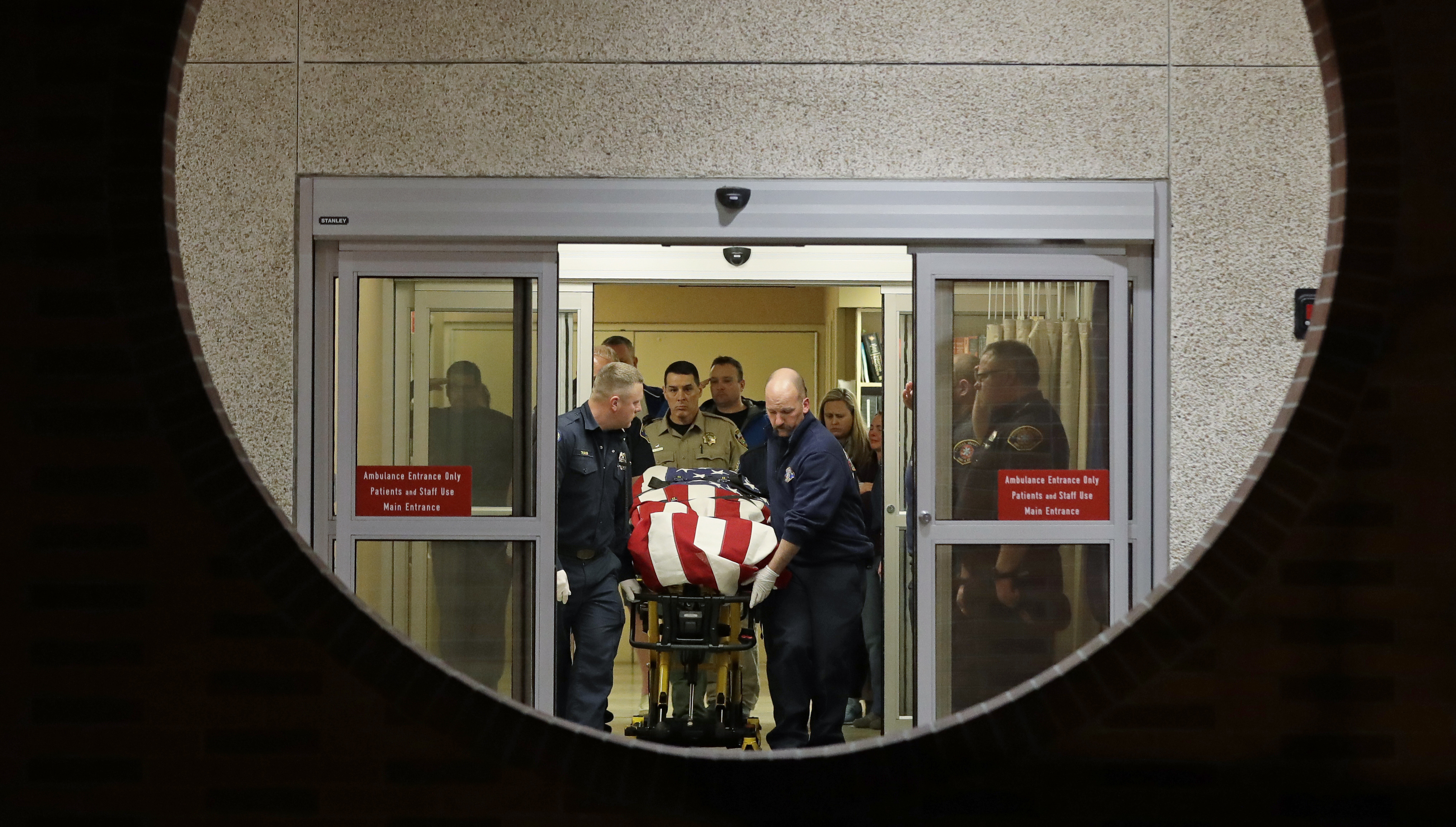 The body of a Kittitas County Sheriff's deputy is draped with a U.S. flag as it is carried out of Kittitas Valley Healthcare Hospital, in the early morning hours of Wednesday, March 20, 2019, in Ellensburg, Wash., as seen through a large circular entry window. A Kittitas County Sheriff's deputy was killed and a police officer was injured after an exchange of gunfire during an attempted traffic stop. (AP Photo/Ted S. Warren) The body of a Kittitas County Sheriff's deputy is draped with a U.S. flag as it is carried out of Kittitas Valley Healthcare Hospital, in the early morning hours of Wednesday, March 20, 2019, in Ellensburg, Wash., as seen through a large circular entry window. A Kittitas County Sheriff's deputy was killed and a police officer was injured after an exchange of gunfire during an attempted traffic stop. (AP Photo/Ted S. Warren)