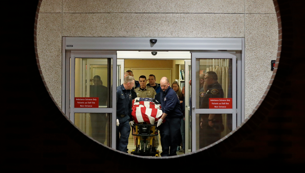 The body of a Kittitas County Sheriff's deputy is draped with a U.S. flag as it is carried out of Kittitas Valley Healthcare Hospital, in the early morning hours of Wednesday, March 20, 2019, in Ellensburg, Wash., as seen through a large circular entry window. A Kittitas County Sheriff's deputy was killed and a police officer was injured after an exchange of gunfire during an attempted traffic stop. (AP Photo/Ted S. Warren) The body of a Kittitas County Sheriff's deputy is draped with a U.S. flag as it is carried out of Kittitas Valley Healthcare Hospital, in the early morning hours of Wednesday, March 20, 2019, in Ellensburg, Wash., as seen through a large circular entry window. A Kittitas County Sheriff's deputy was killed and a police officer was injured after an exchange of gunfire during an attempted traffic stop. (AP Photo/Ted S. Warren)