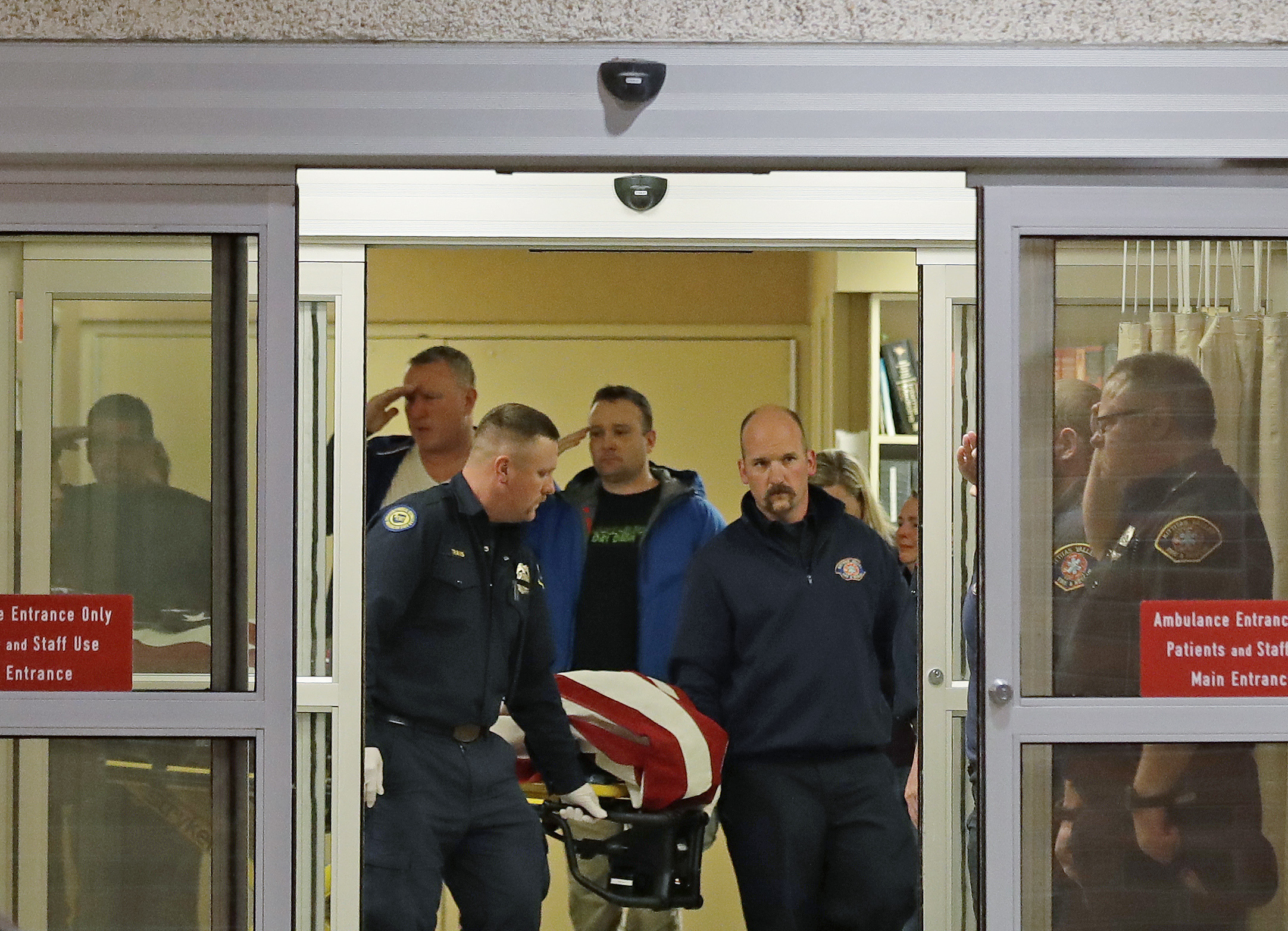 Fire and law enforcement officials join others in saluting as the body of a Kittitas County Sheriff's deputy draped with a U.S. flag is carried out of Kittitas Valley Healthcare Hospital, in the early morning hours of Wednesday, March 20, 2019, in Ellensburg, Wash. A Kittitas County Sheriff's deputy was killed and a police officer was injured after an exchange of gunfire during an attempted traffic stop. (AP Photo/Ted S. Warren) Fire and law enforcement officials join others in saluting as the body of a Kittitas County Sheriff's deputy draped with a U.S. flag is carried out of Kittitas Valley Healthcare Hospital, in the early morning hours of Wednesday, March 20, 2019, in Ellensburg, Wash. A Kittitas County Sheriff's deputy was killed and a police officer was injured after an exchange of gunfire during an attempted traffic stop. (AP Photo/Ted S. Warren)