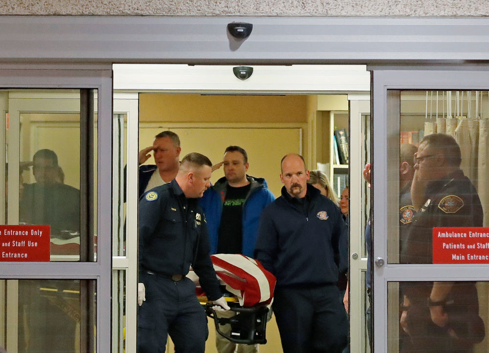 Fire and law enforcement officials join others in saluting as the body of a Kittitas County Sheriff's deputy draped with a U.S. flag is carried out of Kittitas Valley Healthcare Hospital, in the early morning hours of Wednesday, March 20, 2019, in Ellensburg, Wash. A Kittitas County Sheriff's deputy was killed and a police officer was injured after an exchange of gunfire during an attempted traffic stop. (AP Photo/Ted S. Warren) Fire and law enforcement officials join others in saluting as the body of a Kittitas County Sheriff's deputy draped with a U.S. flag is carried out of Kittitas Valley Healthcare Hospital, in the early morning hours of Wednesday, March 20, 2019, in Ellensburg, Wash. A Kittitas County Sheriff's deputy was killed and a police officer was injured after an exchange of gunfire during an attempted traffic stop. (AP Photo/Ted S. Warren)
