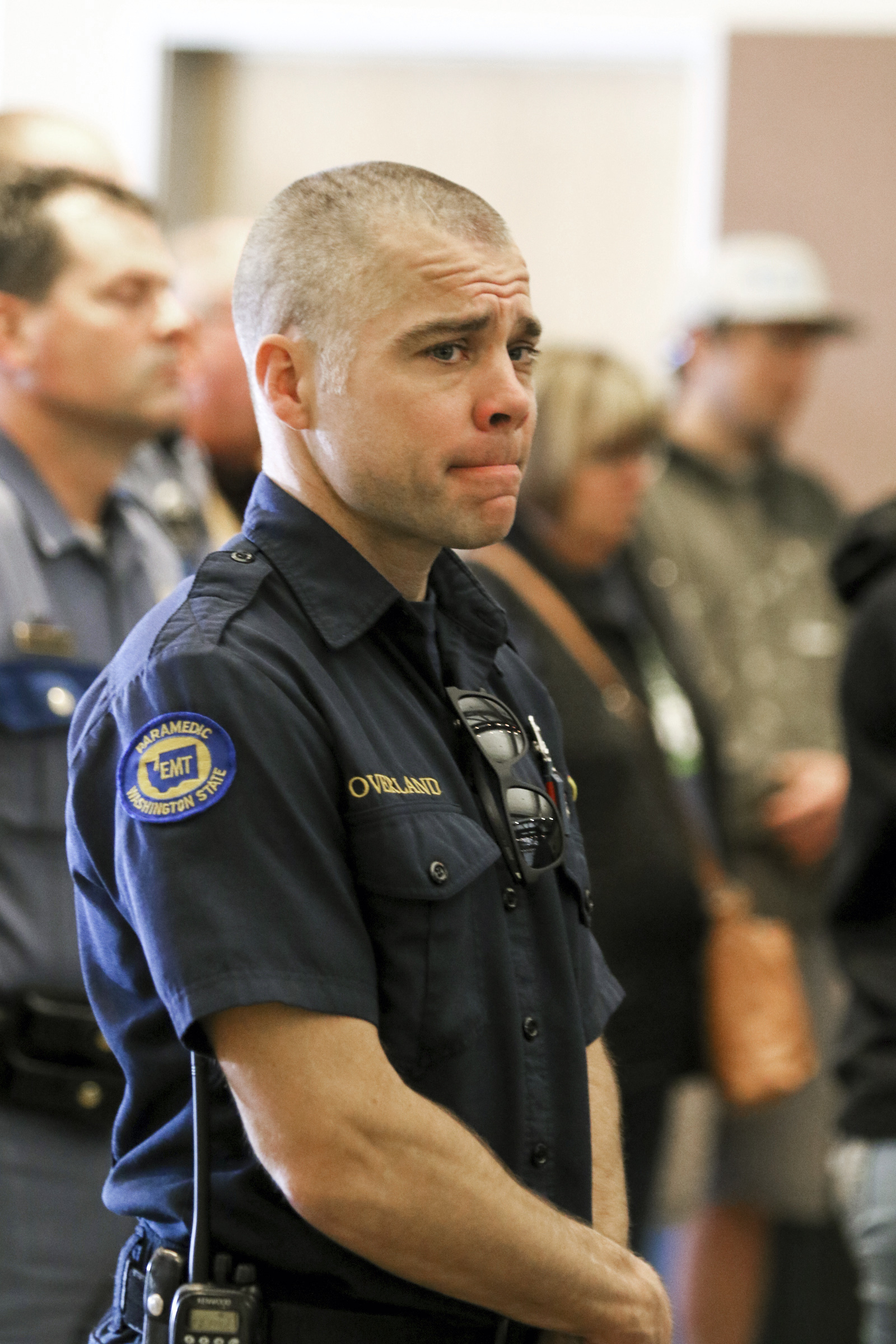 An EMT reacts while listening to Kittitas County Sheriff Gene Dana, not shown, speak at a news conference, Wednesday, March 20, 2019, in Ellensburg, Wash. about the death of Deputy Ryan Thompson, who was killed Tuesday evening when he and a Kittitas Police officer exchanged gunfire with a road-rage driving suspect in Kittitas, Wash. The driver of the vehicle was also shot and later died at a hospital. (Jake Green/The Daily Record via AP) An EMT reacts while listening to Kittitas County Sheriff Gene Dana, not shown, speak at a news conference, Wednesday, March 20, 2019, in Ellensburg, Wash. about the death of Deputy Ryan Thompson, who was killed Tuesday evening when he and a Kittitas Police officer exchanged gunfire with a road-rage driving suspect in Kittitas, Wash. The driver of the vehicle was also shot and later died at a hospital. (Jake Green/The Daily Record via AP)
