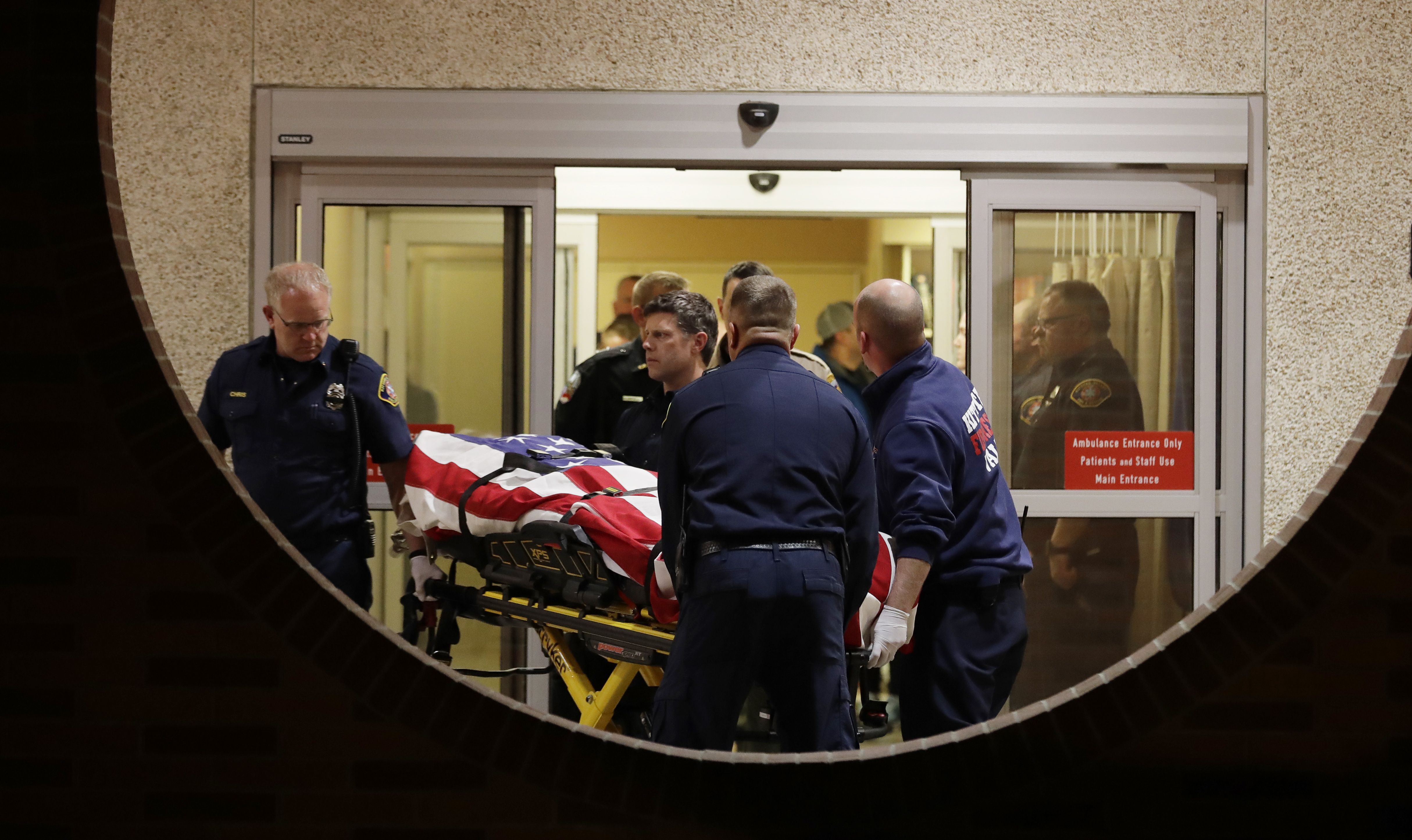 The body of a Kittitas County Sheriff's deputy is draped with a U.S. flag as it is carried out of Kittitas Valley Healthcare Hospital, in the early morning hours of Wednesday, March 20, 2019, in Ellensburg, Wash., as seen through a large circular entry window. A Kittitas County Sheriff's deputy was killed and a police officer was injured after an exchange of gunfire during an attempted traffic stop. (AP Photo/Ted S. Warren) The body of a Kittitas County Sheriff's deputy is draped with a U.S. flag as it is carried out of Kittitas Valley Healthcare Hospital, in the early morning hours of Wednesday, March 20, 2019, in Ellensburg, Wash., as seen through a large circular entry window. A Kittitas County Sheriff's deputy was killed and a police officer was injured after an exchange of gunfire during an attempted traffic stop. (AP Photo/Ted S. Warren)