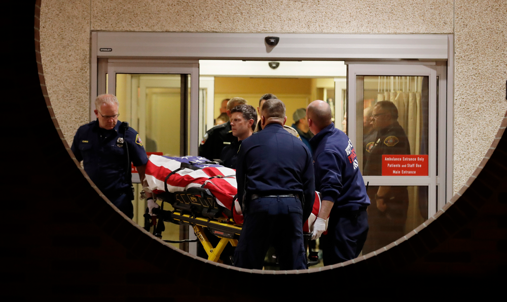 The body of a Kittitas County Sheriff's deputy is draped with a U.S. flag as it is carried out of Kittitas Valley Healthcare Hospital, in the early morning hours of Wednesday, March 20, 2019, in Ellensburg, Wash., as seen through a large circular entry window. A Kittitas County Sheriff's deputy was killed and a police officer was injured after an exchange of gunfire during an attempted traffic stop. (AP Photo/Ted S. Warren) The body of a Kittitas County Sheriff's deputy is draped with a U.S. flag as it is carried out of Kittitas Valley Healthcare Hospital, in the early morning hours of Wednesday, March 20, 2019, in Ellensburg, Wash., as seen through a large circular entry window. A Kittitas County Sheriff's deputy was killed and a police officer was injured after an exchange of gunfire during an attempted traffic stop. (AP Photo/Ted S. Warren)