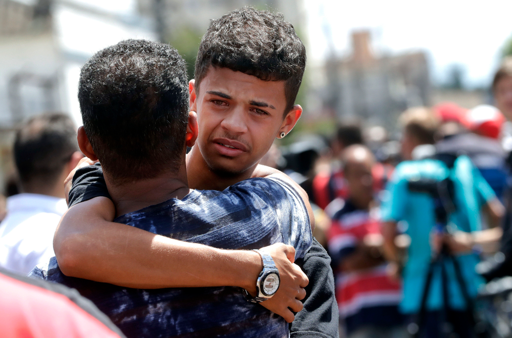 A former student is comforted by a friend outside the Raul Brasil State School in Suzano, the greater Sao Paulo area, Brazil, Wednesday, March 13, 2019. The state government of Sao Paulo said two teenagers, armed with guns and wearing hoods, entered the school and began shooting at students. They then killed themselves, according to the statement. (AP Photo/Andre Penner) A former student is comforted by a friend outside the Raul Brasil State School in Suzano, the greater Sao Paulo area, Brazil, Wednesday, March 13, 2019. The state government of Sao Paulo said two teenagers, armed with guns and wearing hoods, entered the school and began shooting at students. They then killed themselves, according to the statement. (AP Photo/Andre Penner)