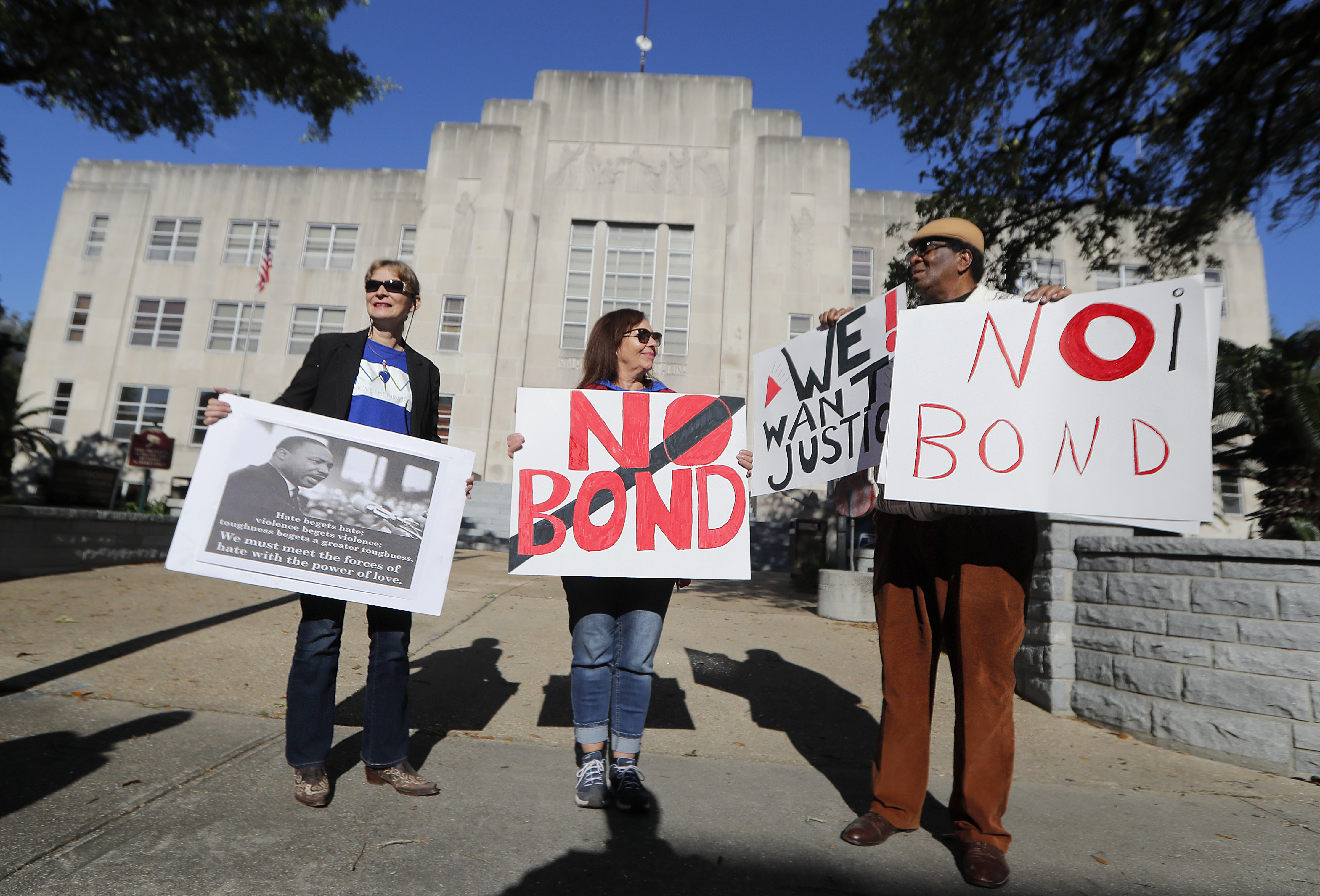 Wilfred Young, Agnes Courbille, left, and Karel Anne Zibe, center, of the St. Landry Parish branch of the NAACP, hold signs outside the St. Landry Parish courthouse during a bond hearing for Holden Matthews in Opelousas, La., Monday, April 15, 2019. Matthews, who is white, and is the son of a St. Landry Parish sheriff's deputy, was arrested Wednesday on three charges of arson of a religious building, and is the suspect in three recent arson fires that destroyed African American churches in Louisiana. (AP Photo/Gerald Herbert) Wilfred Young, Agnes Courbille, left, and Karel Anne Zibe, center, of the St. Landry Parish branch of the NAACP, hold signs outside the St. Landry Parish courthouse during a bond hearing for Holden Matthews in Opelousas, La., Monday, April 15, 2019. Matthews, who is white, and is the son of a St. Landry Parish sheriff's deputy, was arrested Wednesday on three charges of arson of a religious building, and is the suspect in three recent arson fires that destroyed African American churches in Louisiana. (AP Photo/Gerald Herbert)