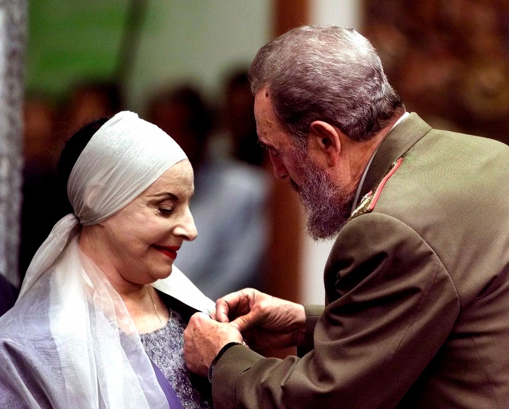 FILE - In this Dec. 20, 2000 file photo, Alicia Alonso, Cuba's grande dame of dance and the founder of the internationally renowned National Ballet of Cuba, receives the Jose Marti medal, Cuba's highest honor, from Cuban leader Fidel Castro, at the Revolution Palace in Havana. Cuba's national ballet has reported that Alonso has died on Thursday, Oct. 17, 2019. (AP Photo/Jose Goitia, File) FILE - In this Dec. 20, 2000 file photo, Alicia Alonso, Cuba's grande dame of dance and the founder of the internationally renowned National Ballet of Cuba, receives the Jose Marti medal, Cuba's highest honor, from Cuban leader Fidel Castro, at the Revolution Palace in Havana. Cuba's national ballet has reported that Alonso has died on Thursday, Oct. 17, 2019. (AP Photo/Jose Goitia, File)