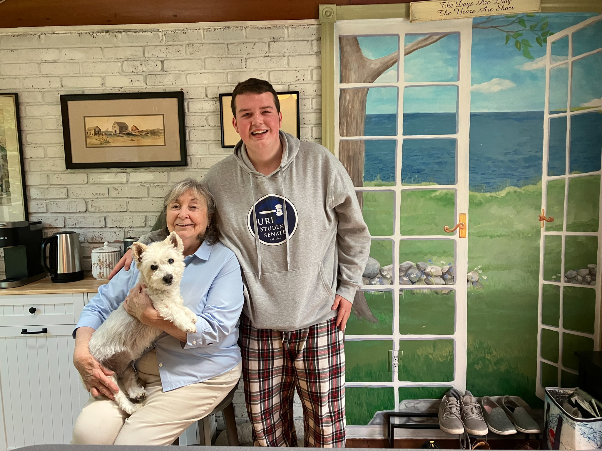 Chris Bove poses for a portrait with his great-grandmother Cheryl Forden and her dog, Sadie, in Warwick, on Thursday, May 25, 2023. Bove moved in with his nana after he graduated from URI because he couldn't find affordable housing in his hometown, Middletown.