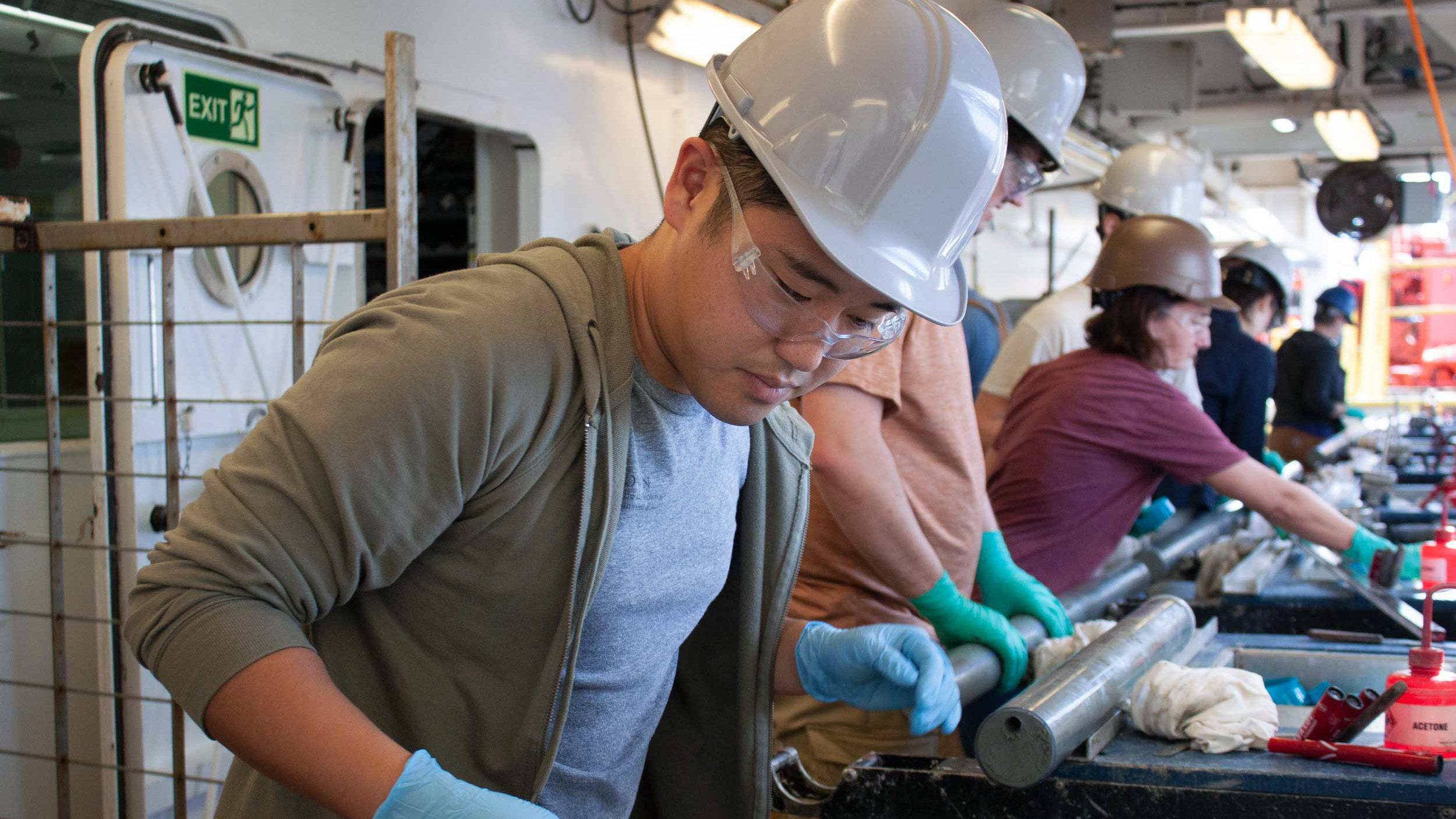 Bryce Mitsunaga, a graduate student at Brown University, tests a sample of sediment from the ocean floor for methane and other gasses on the catwalk of the JOIDES Resolution.