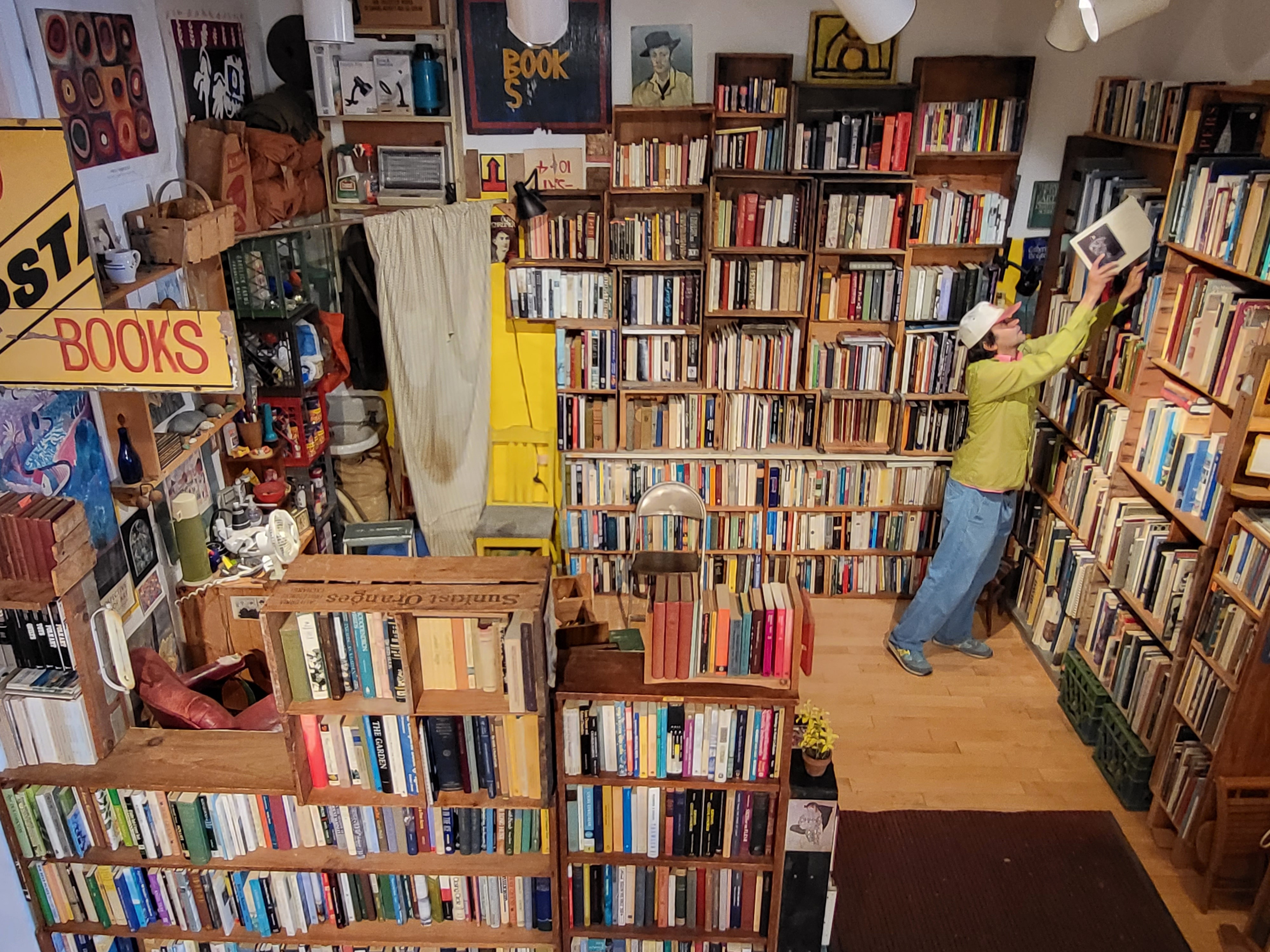 Carl Simmons reshelves a book inside his recreation of Ira Cohen’s bookstore.