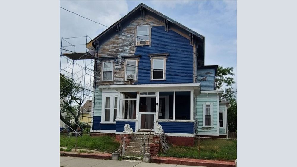  Omar Benitez repainted the exterior of his Central Falls house to contain peeling lead-based paint. 
