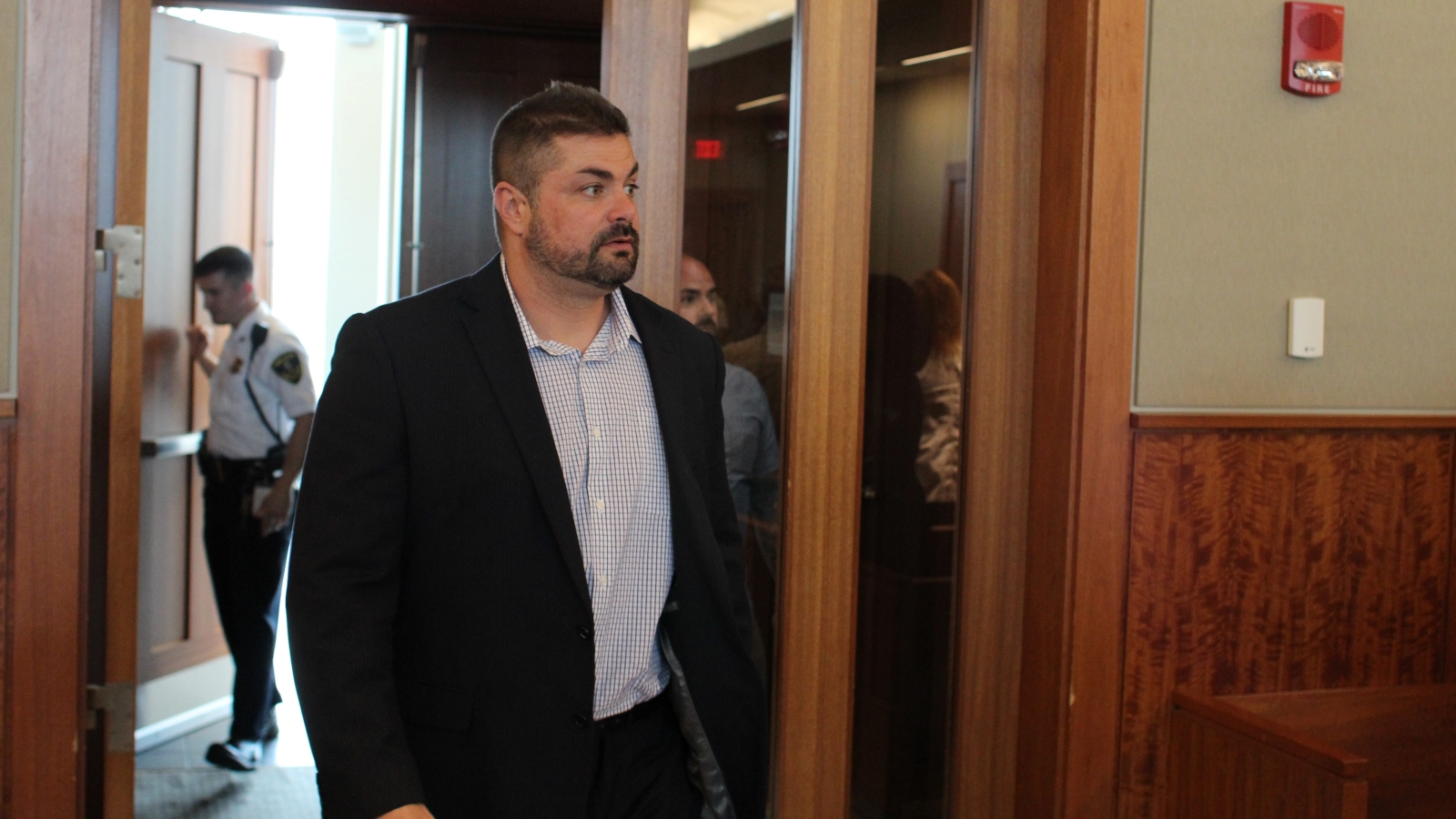 Former Fall River police officer Michael Pessoa walks into a courtroom at the city's Superior Court.