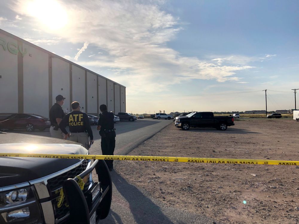 Bureau of Alcohol, Tobacco, Firearms and Explosives agents speak with a local police officer in a gravel lot next to an Odessa, Texas, movie theater Sunday, Sept. 1, 2019, where authorities say the suspected shooter in Saturday's rampage was killed. The death toll in the West Texas shooting rampage increased to Sunday as authorities investigated why a man stopped by state troopers for failing to signal a left turn opened fire on them and fled, shooting over a dozen people as he drove before being killed by officers outside a movie theater. (AP Photo/Jake Bleiberg) Bureau of Alcohol, Tobacco, Firearms and Explosives agents speak with a local police officer in a gravel lot next to an Odessa, Texas, movie theater Sunday, Sept. 1, 2019, where authorities say the suspected shooter in Saturday's rampage was killed. The death toll in the West Texas shooting rampage increased to Sunday as authorities investigated why a man stopped by state troopers for failing to signal a left turn opened fire on them and fled, shooting over a dozen people as he drove before being killed by officers outside a movie theater. (AP Photo/Jake Bleiberg)
