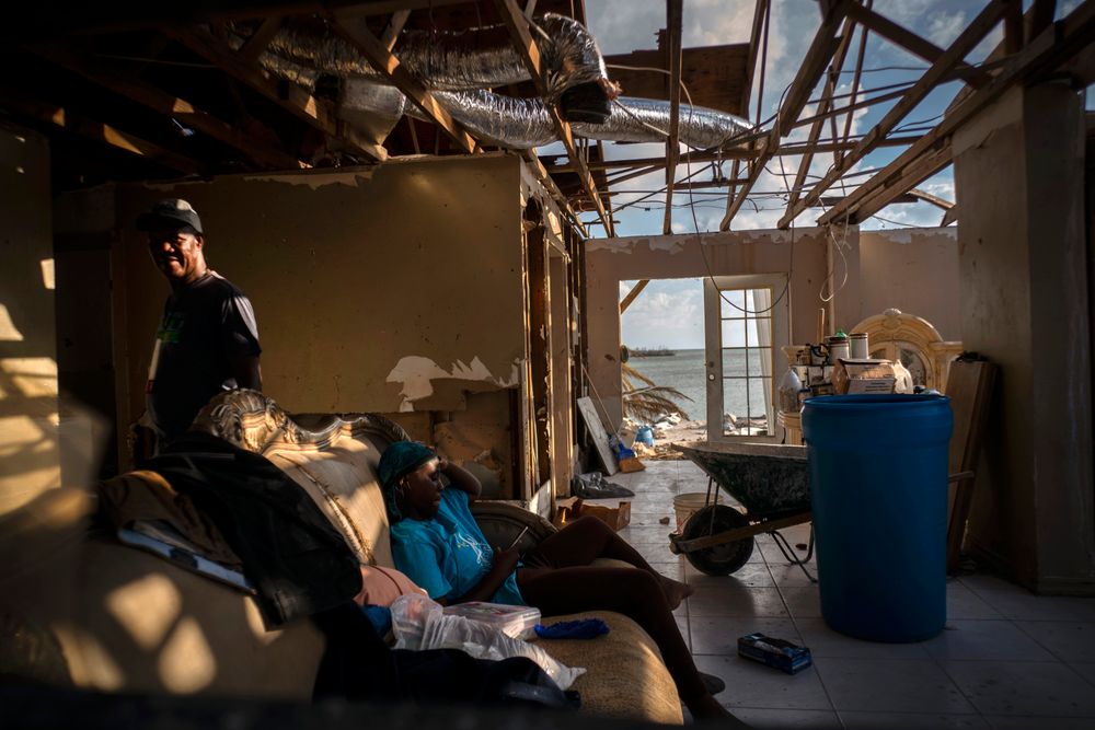Phil Thomas, left, walks next to his daughter Ebony Thomas as she looks at her phone inside their home, shattered by Hurricane Dorian in Mclean's Town, Grand Bahama, Bahamas, Wednesday Sept. 11, 2019. Phil lost three members of his family in the Hurricane. (AP Photo / Ramon Espinosa) Phil Thomas, left, walks next to his daughter Ebony Thomas as she looks at her phone inside their home, shattered by Hurricane Dorian in Mclean's Town, Grand Bahama, Bahamas, Wednesday Sept. 11, 2019. Phil lost three members of his family in the Hurricane. (AP Photo / Ramon Espinosa)