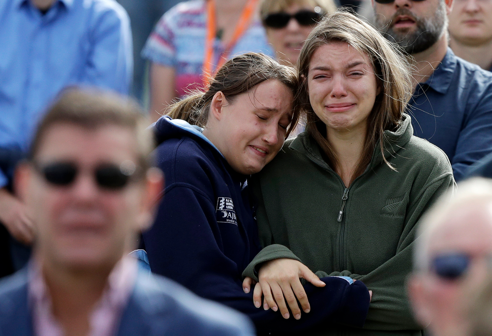 In this Friday, March 29, 2019, file photo, women react as the New Zealand national anthem is sung during a national remembrance service in Hagley Park for the victims of the March 15 mosque terrorist attack in Christchurch, New Zealand. (AP Photo/Mark Baker, File) In this Friday, March 29, 2019, file photo, women react as the New Zealand national anthem is sung during a national remembrance service in Hagley Park for the victims of the March 15 mosque terrorist attack in Christchurch, New Zealand. (AP Photo/Mark Baker, File)