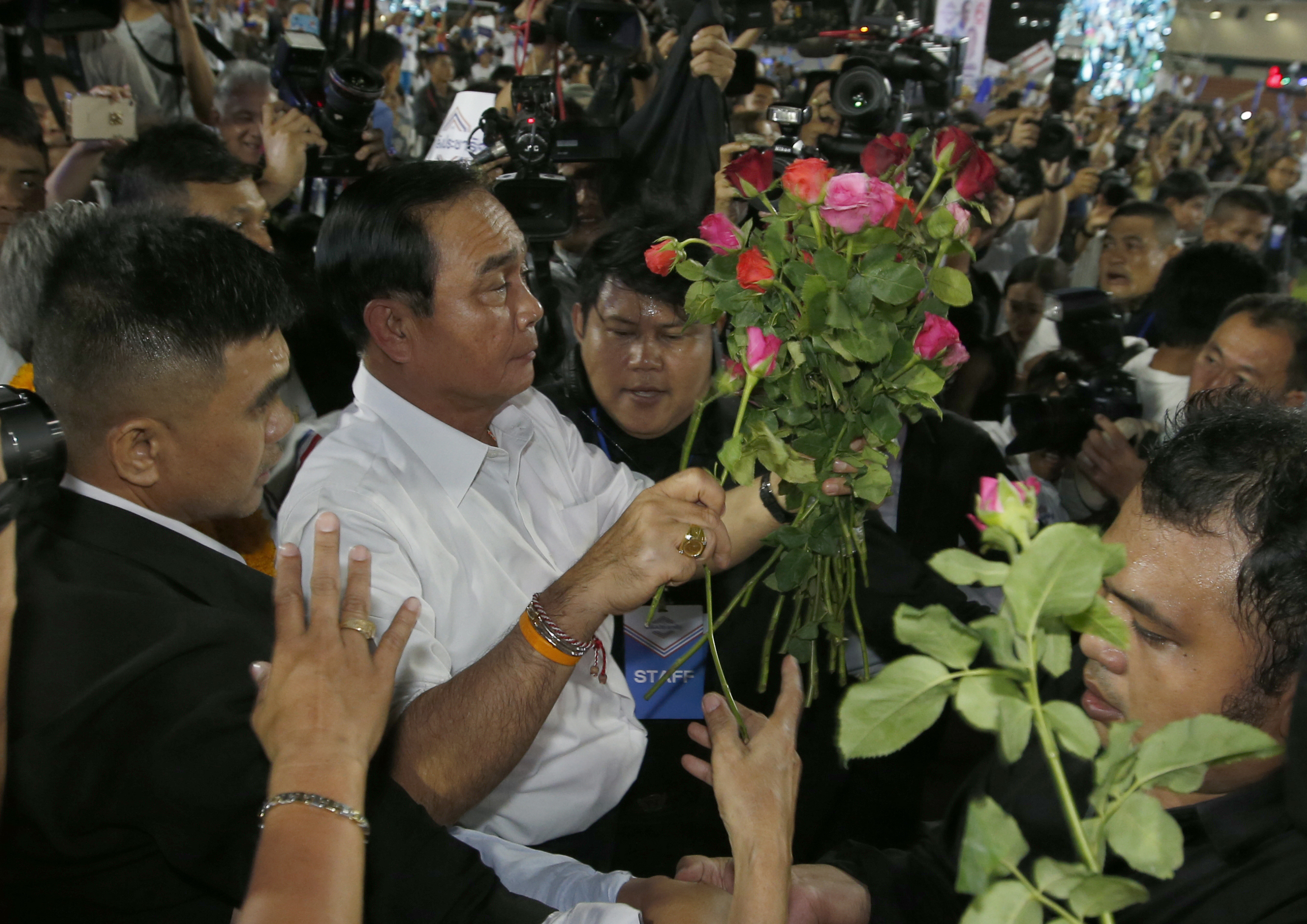 Thai Prime Minister Prayuth Chan-ocha of the Palang Pracharat Party receives flowers from supporters during an election campaign rally in Bangkok, Thailand, Friday, March 22, 2019. The political movement that has won every Thai election in nearly two decades is facing its biggest test yet: Squaring off against the allies of the military junta that removed it from power and rewrote the electoral rules with the goal of putting an end to those victories. (AP Photo/Sakchai Lalit) Thai Prime Minister Prayuth Chan-ocha of the Palang Pracharat Party receives flowers from supporters during an election campaign rally in Bangkok, Thailand, Friday, March 22, 2019. The political movement that has won every Thai election in nearly two decades is facing its biggest test yet: Squaring off against the allies of the military junta that removed it from power and rewrote the electoral rules with the goal of putting an end to those victories. (AP Photo/Sakchai Lalit)
