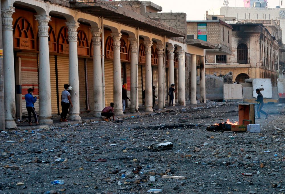 Demonstrators take cover during clashes between security forces and anti-government protesters in the historic Rasheed Street, Baghdad, Iraq, Sunday, Nov. 24, 2019. Hundreds of people have died since demonstrations began Oct. 1, when thousands of Iraqis, mostly youth, took to the streets to decry corruption and poor services. The leaderless uprising seeks to overthrow the political establishment. (AP Photo/Khalid Mohammed) Demonstrators take cover during clashes between security forces and anti-government protesters in the historic Rasheed Street, Baghdad, Iraq, Sunday, Nov. 24, 2019. Hundreds of people have died since demonstrations began Oct. 1, when thousands of Iraqis, mostly youth, took to the streets to decry corruption and poor services. The leaderless uprising seeks to overthrow the political establishment. (AP Photo/Khalid Mohammed)