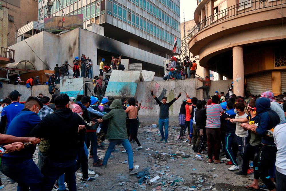 Demonstrators try to pull down concrete walls placed by Iraqi security forces to close in the historic Rasheed Street during clashes between security forces and anti-government protesters in Baghdad, Iraq, Sunday, Nov. 24, 2019. (AP Photo/Khalid Mohammed) Demonstrators try to pull down concrete walls placed by Iraqi security forces to close in the historic Rasheed Street during clashes between security forces and anti-government protesters in Baghdad, Iraq, Sunday, Nov. 24, 2019. (AP Photo/Khalid Mohammed)