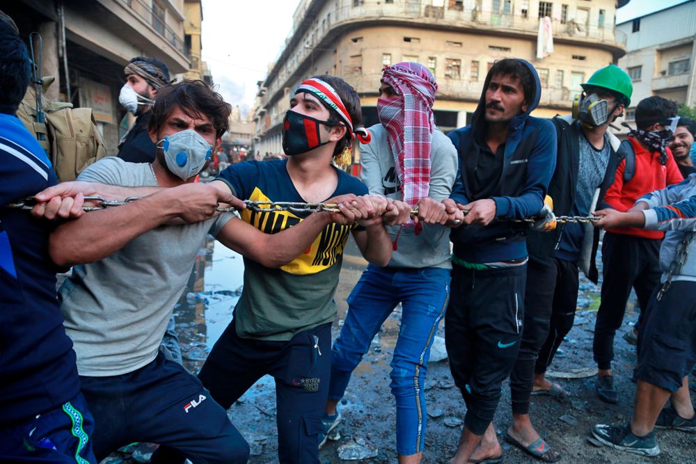 Demonstrators try to pull down concrete walls placed by Iraqi security forces to close in the historic Rasheed Street during clashes between security forces and anti-government protesters in Baghdad, Iraq, Sunday, Nov. 24, 2019. Hundreds of people have died since demonstrations began Oct. 1, when thousands of Iraqis, mostly youth, took to the streets to decry corruption and poor services. The leaderless uprising seeks to overthrow the political establishment. (AP Photo/Khalid Mohammed) Demonstrators try to pull down concrete walls placed by Iraqi security forces to close in the historic Rasheed Street during clashes between security forces and anti-government protesters in Baghdad, Iraq, Sunday, Nov. 24, 2019. Hundreds of people have died since demonstrations began Oct. 1, when thousands of Iraqis, mostly youth, took to the streets to decry corruption and poor services. The leaderless uprising seeks to overthrow the political establishment. (AP Photo/Khalid Mohammed)