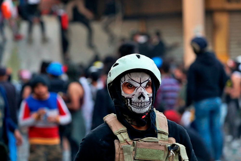 A protester wears a mask during clashes with security forces, in Baghdad, Iraq, Sunday, Nov. 24, 2019. At least sixteen people were killed and over 100 wounded in the renewed clashes, which kicked off Thursday as protesters tried to scale a concrete barrier on historic Rasheed Street prompting security forces to fire live ammunition, tear gas and rubber bullets to disperse them. (AP Photo/Khalid Mohammed) A protester wears a mask during clashes with security forces, in Baghdad, Iraq, Sunday, Nov. 24, 2019. At least sixteen people were killed and over 100 wounded in the renewed clashes, which kicked off Thursday as protesters tried to scale a concrete barrier on historic Rasheed Street prompting security forces to fire live ammunition, tear gas and rubber bullets to disperse them. (AP Photo/Khalid Mohammed)